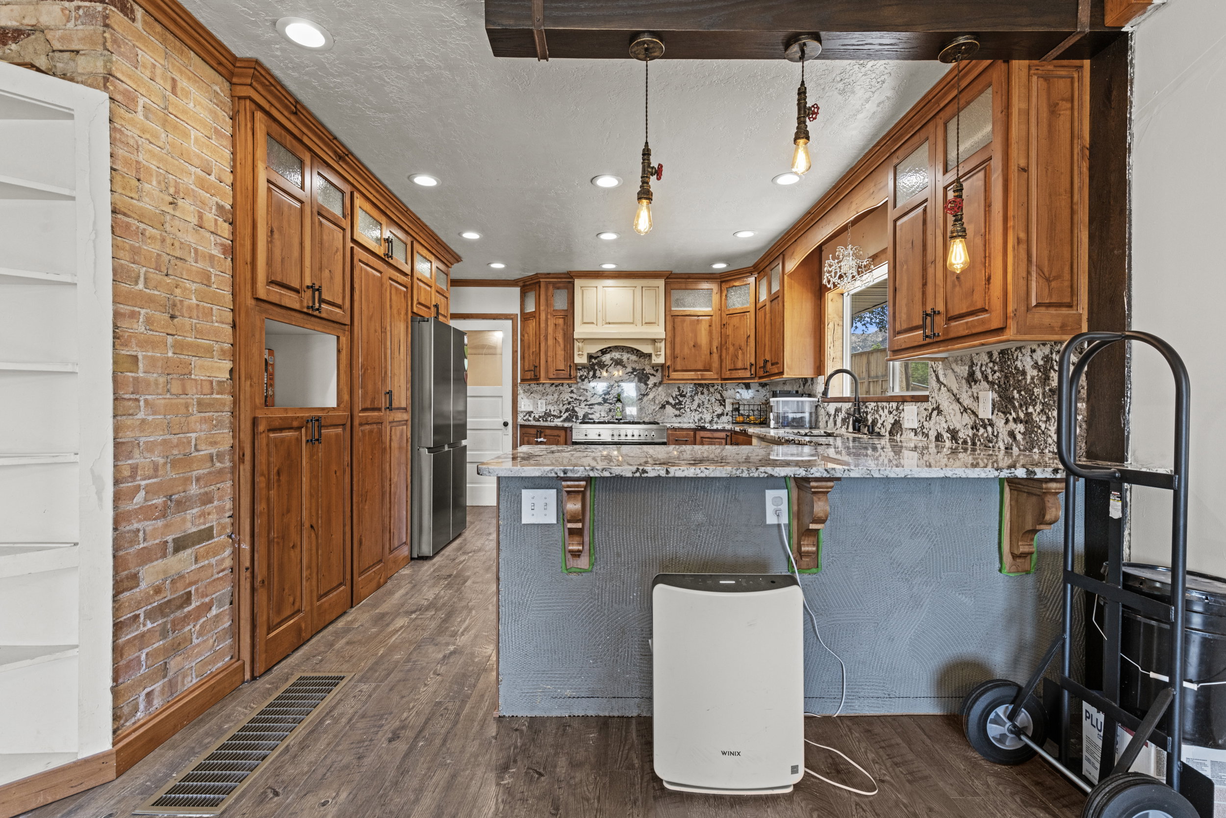 Kitchen featuring wood-finish cabinetry, granite countertops, and recessed lighting