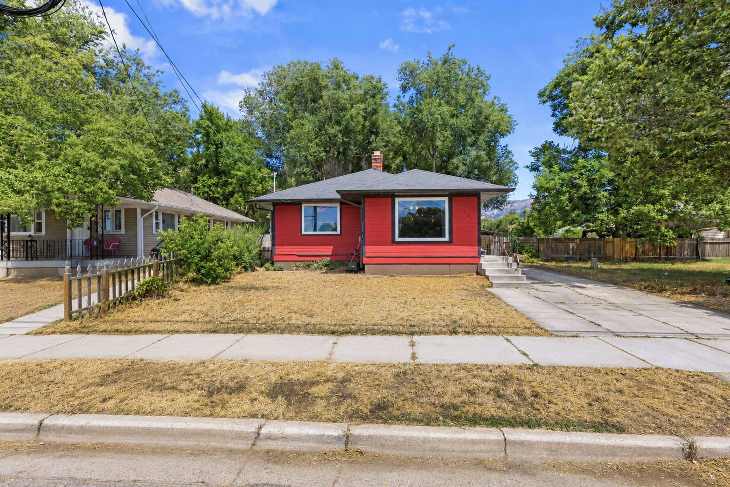 Red exterior with black trim, featuring a dark shingle roof and a prominent front window
