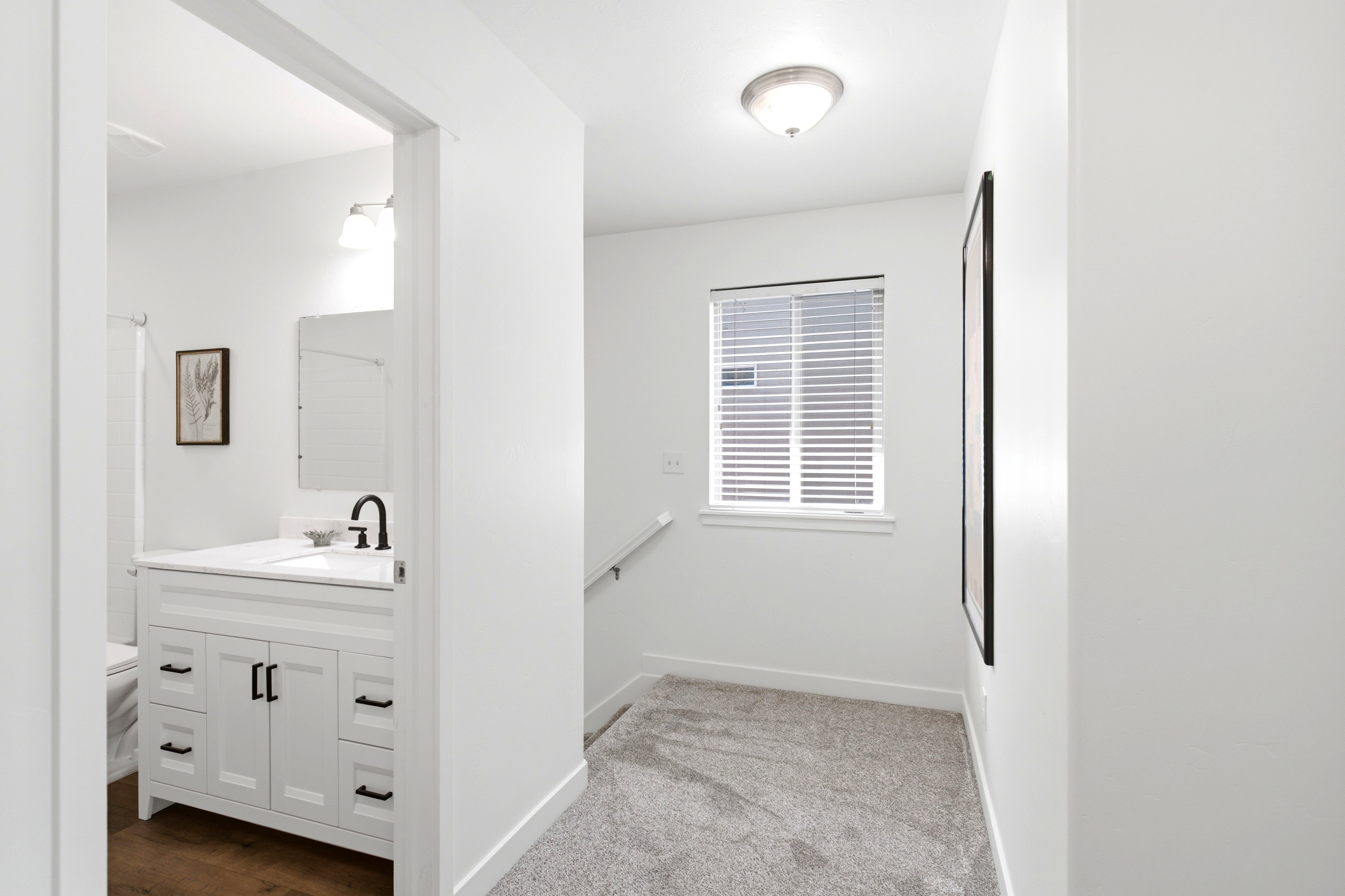 Bathroom entry featuring a white vanity with black hardware, a black-finish faucet, and a large mirror