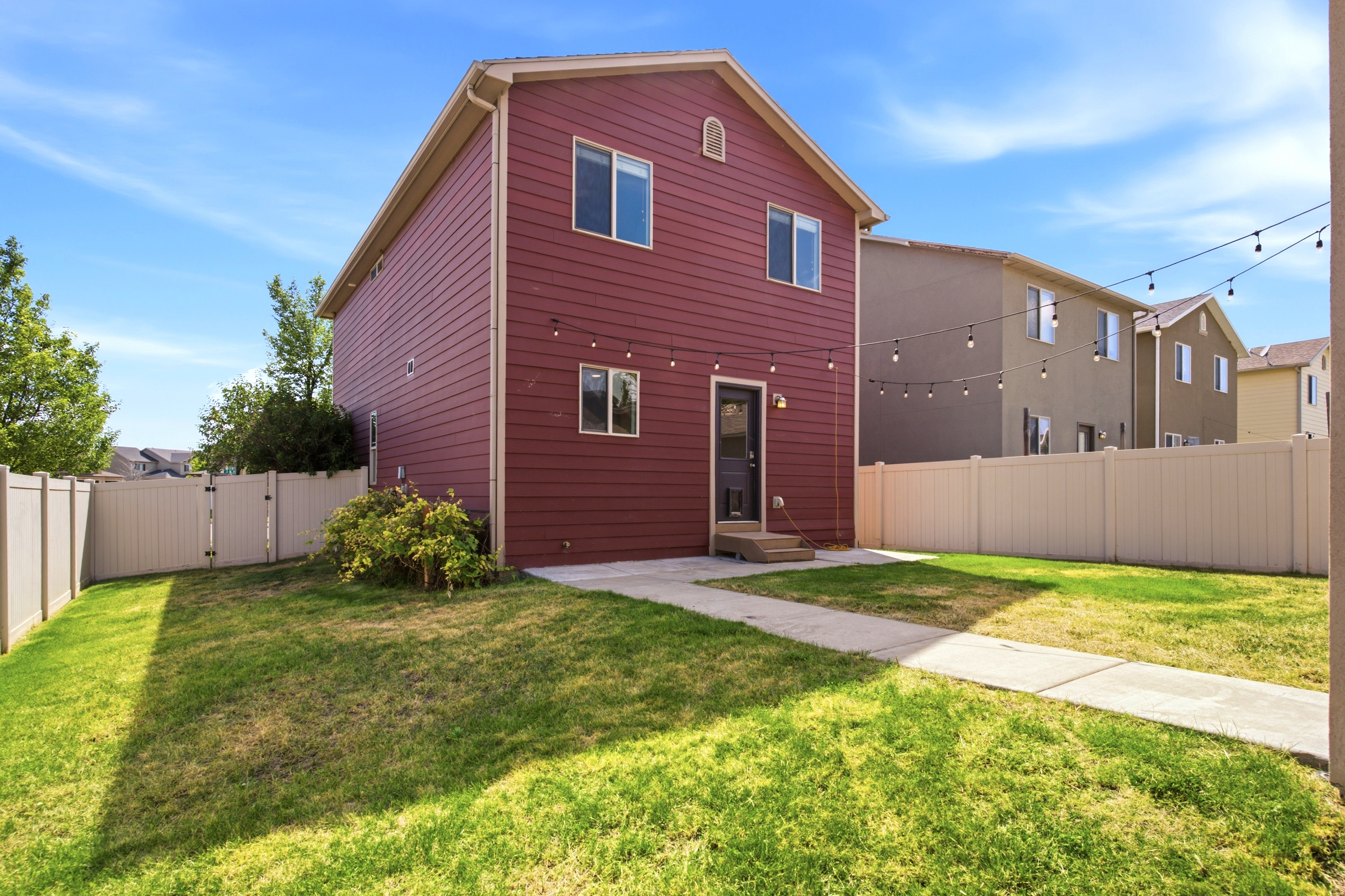 Two-story residence featuring a red siding exterior and white trim