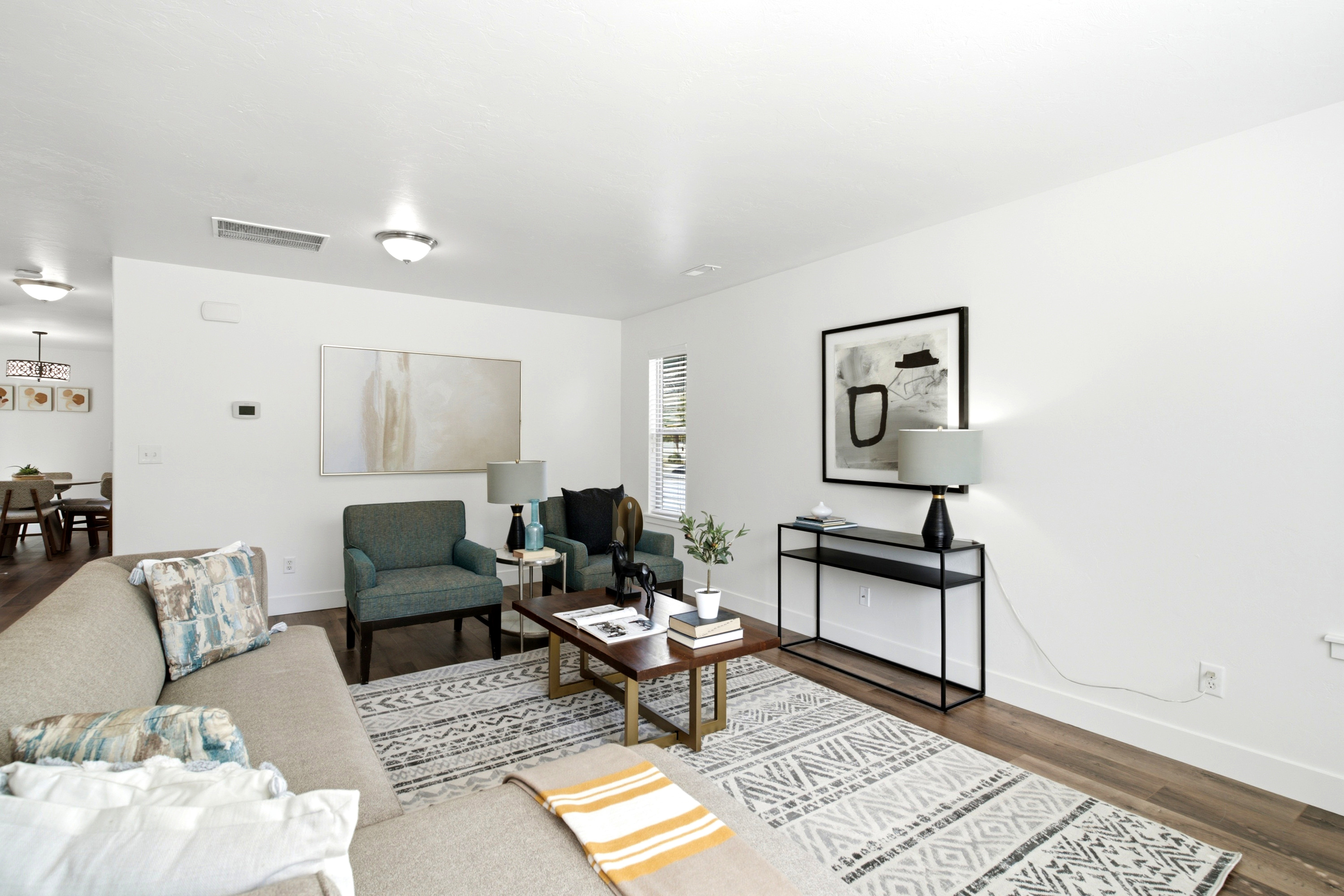 Spacious living area featuring light wood-finish flooring, white walls, and recessed lighting