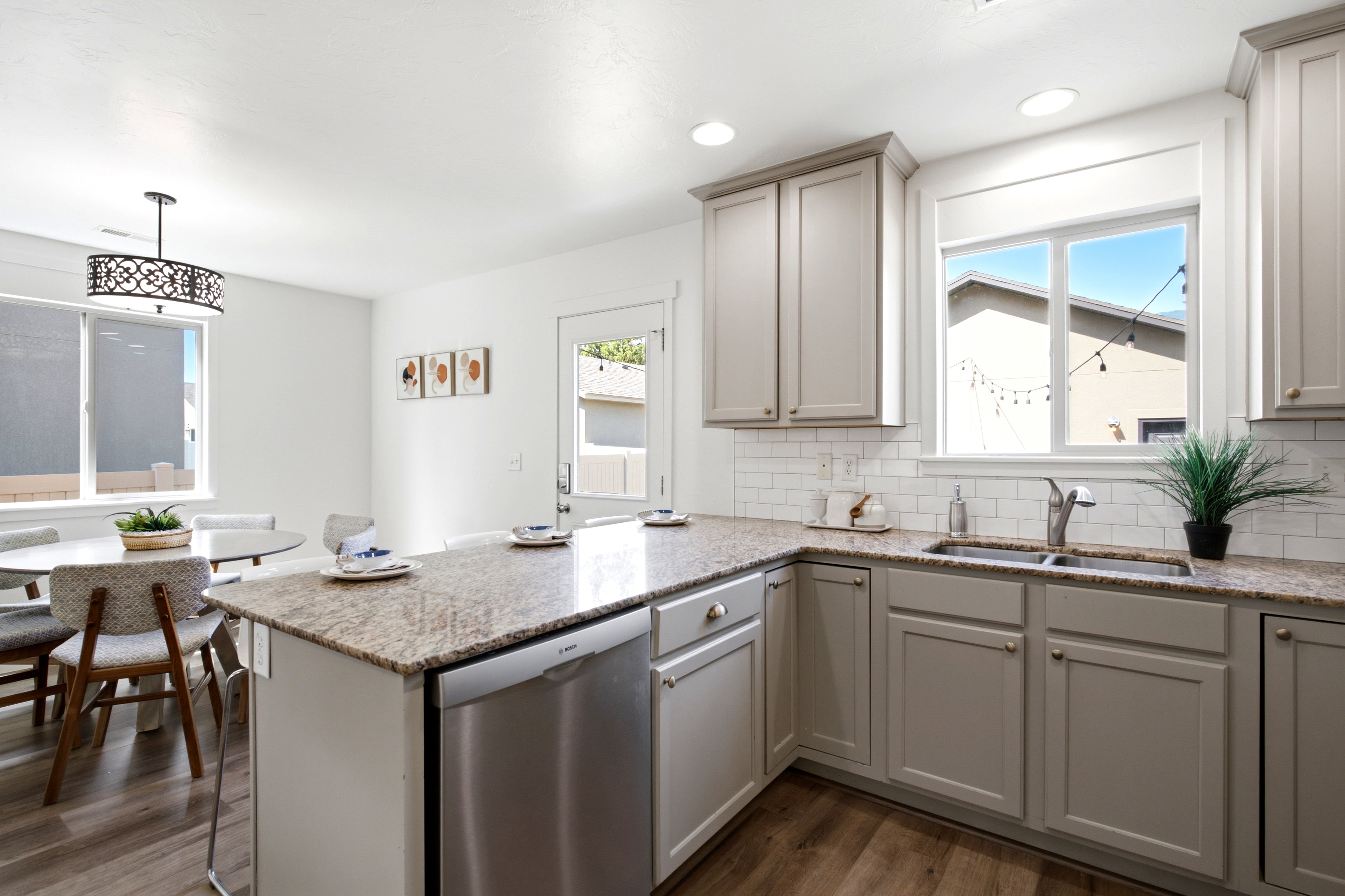 Kitchen featuring light gray cabinetry, stainless steel appliances, a double basin sink, and granite countertops