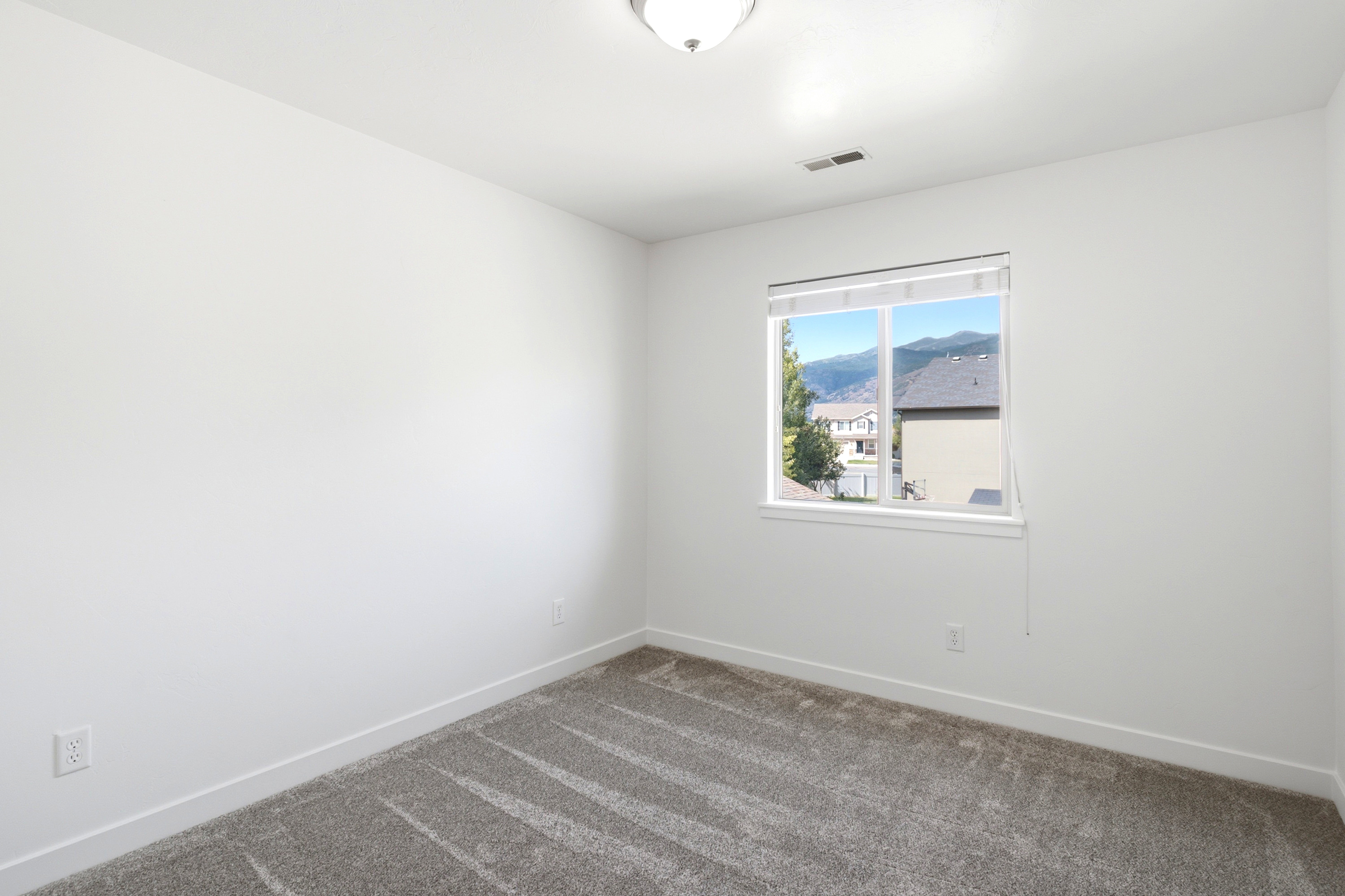 Bright interior room featuring a large window with mountain scenery