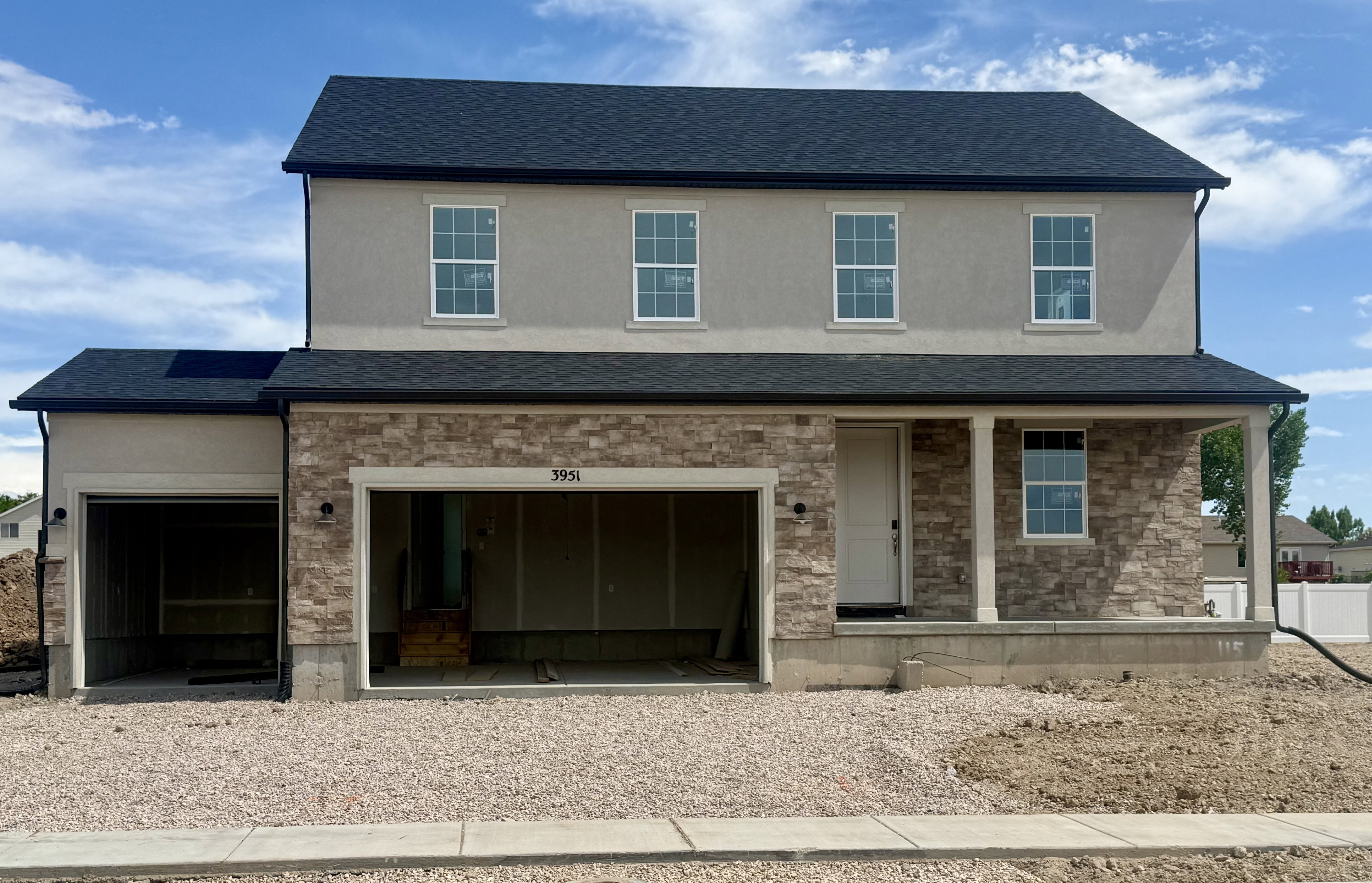 Two-story home featuring a stone and stucco exterior. This image is the actual home being built!