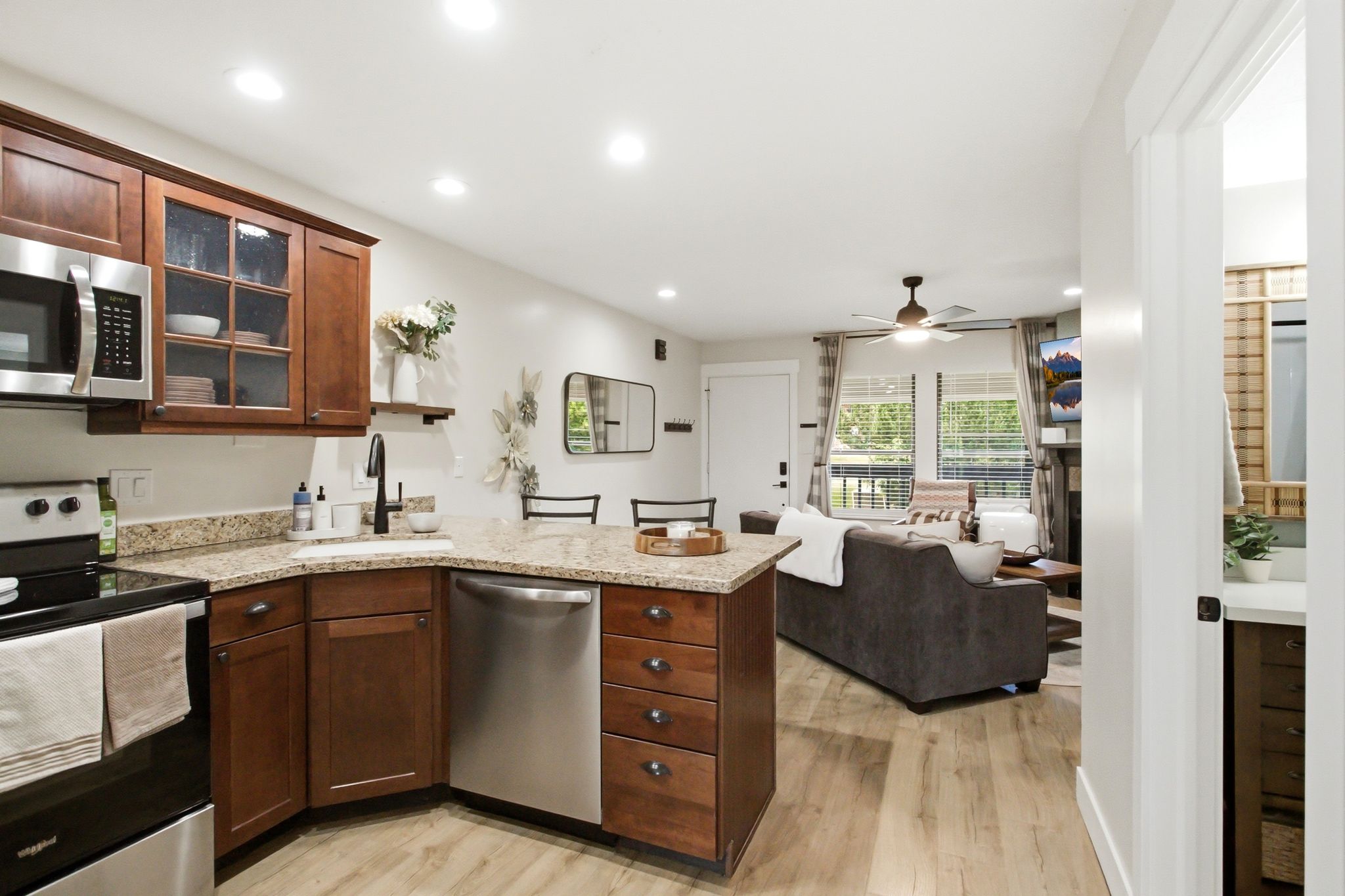 Open-concept kitchen featuring wood-finish flooring, recessed lighting, and granite countertops