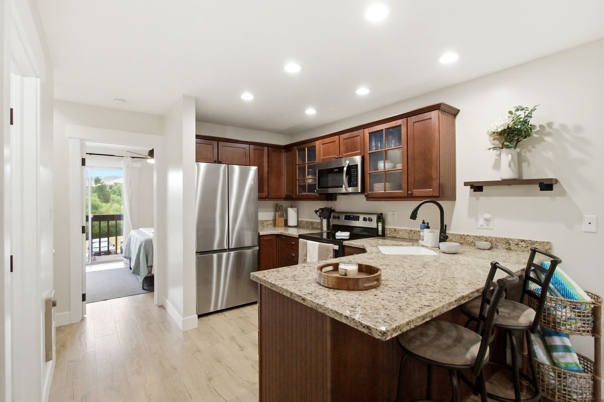 Kitchen featuring wood-finish flooring, recessed lighting, and a breakfast bar with stone countertops