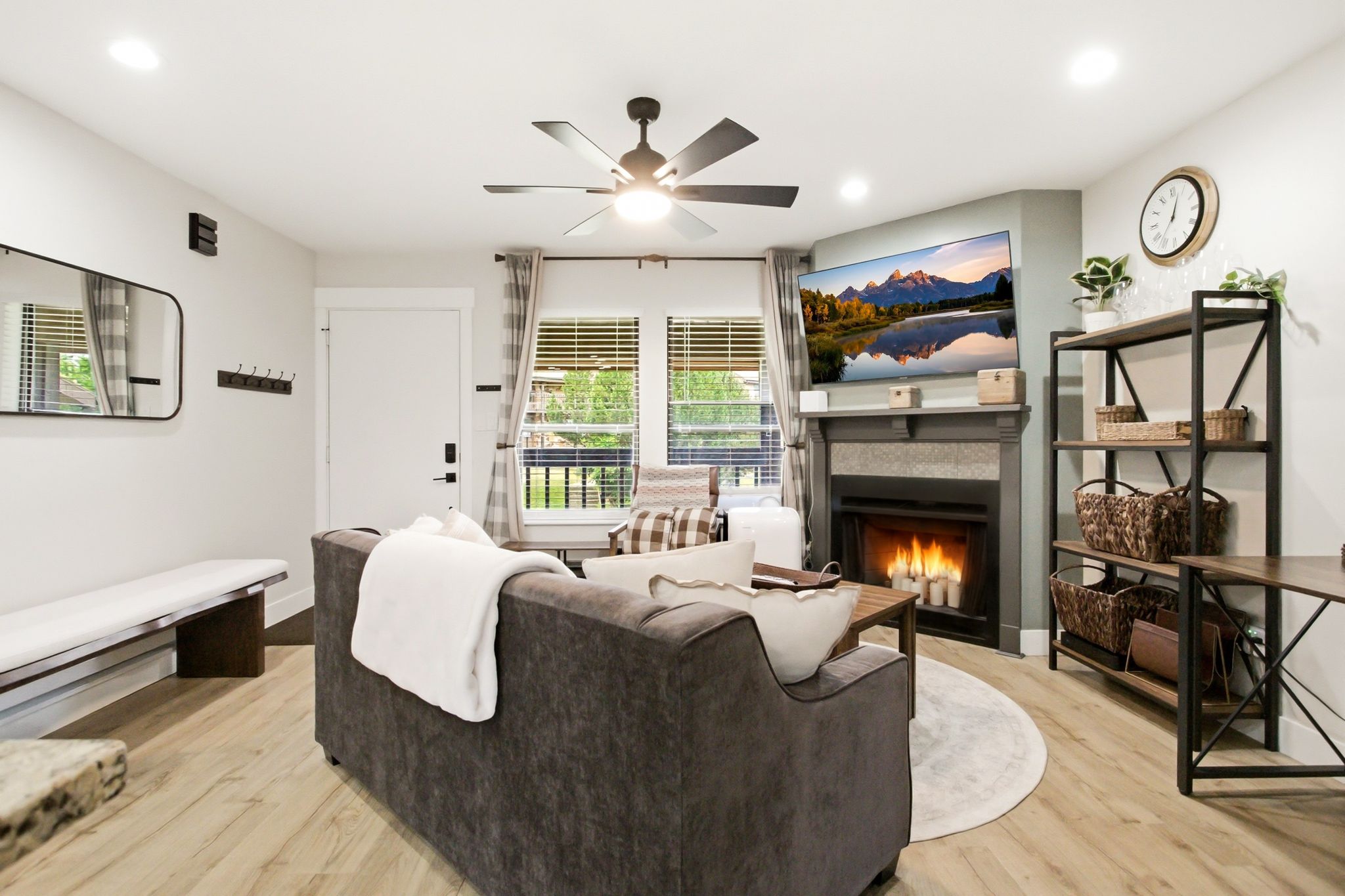 Living area featuring a corner fireplace with a stone surround, a mantel, and a mounted flat-screen television