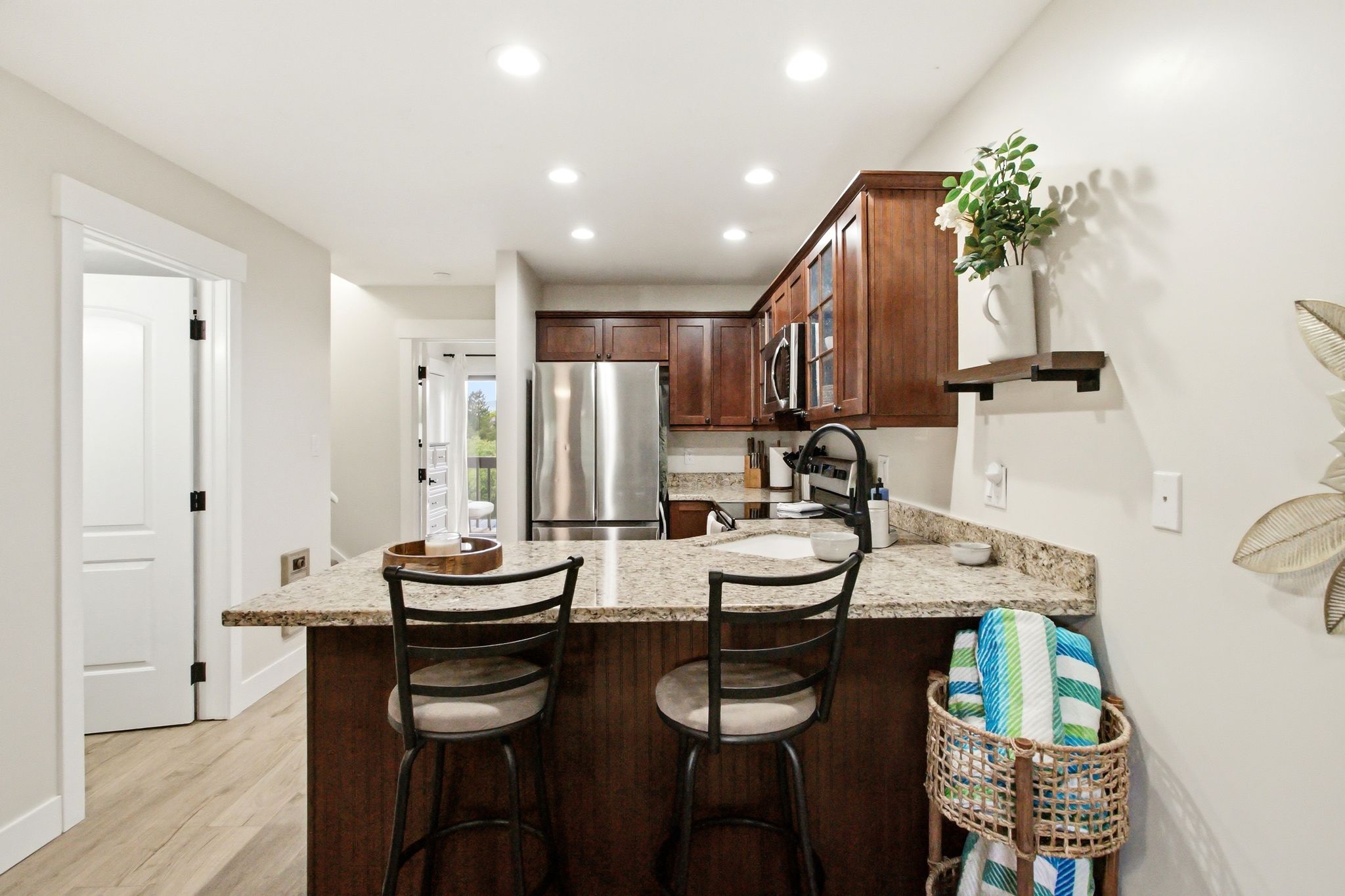 Kitchen featuring wood-finish cabinetry, stainless steel appliances, speckled stone countertops, and recessed lighting