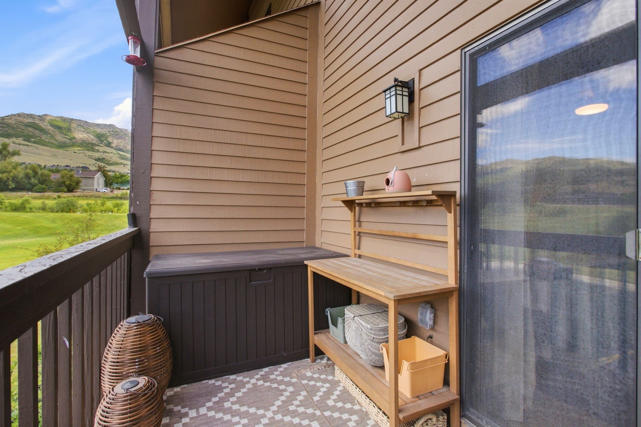 Patio area with wood-finish siding, a dark-toned privacy wall, and a full-light glass door