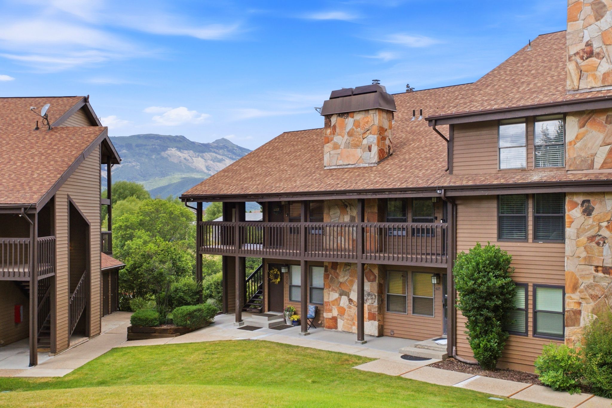 Multi-level residences featuring brown siding and natural stone accents