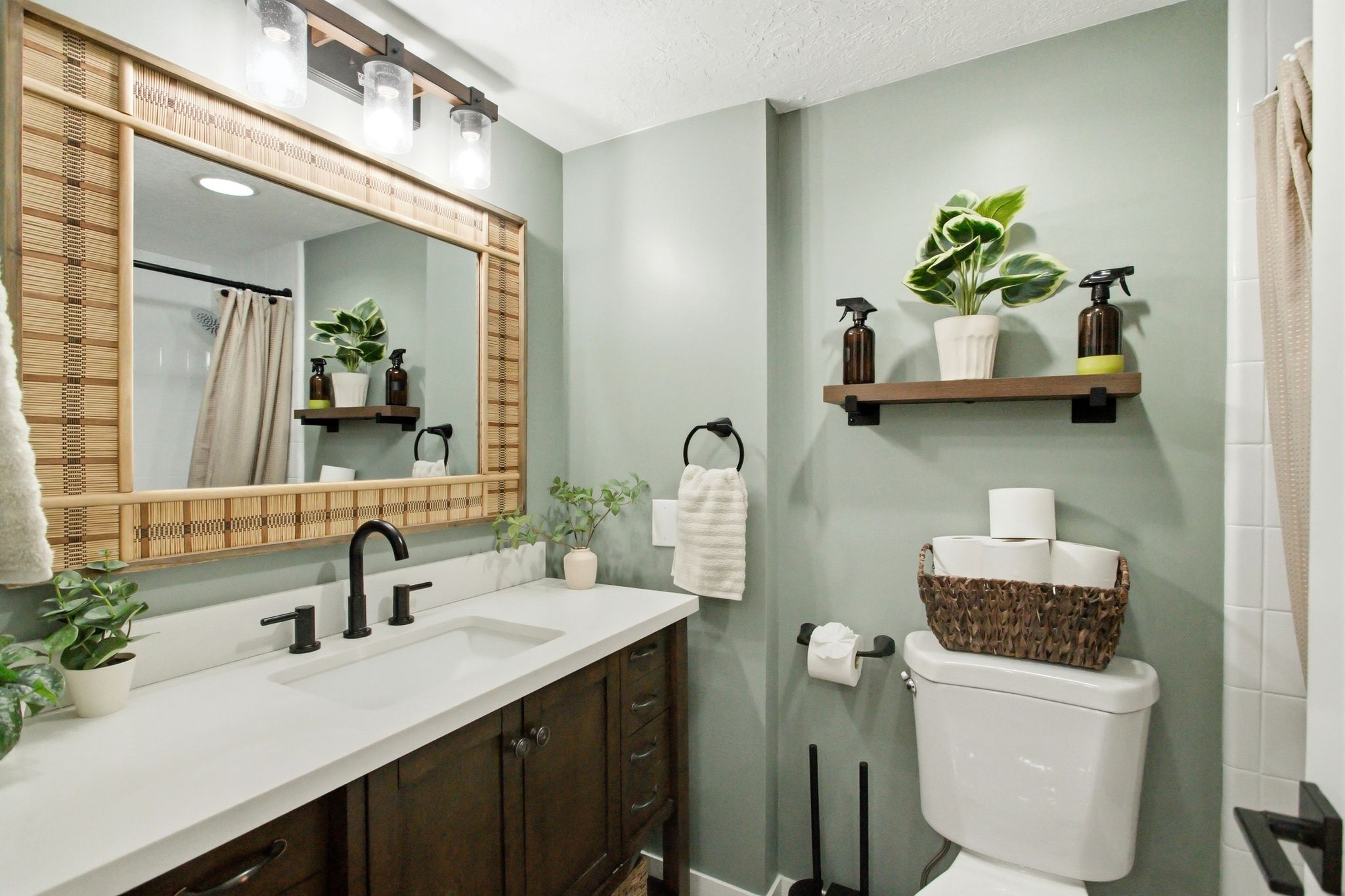 Vanity featuring a white countertop with an integrated sink, dark wood-finish cabinetry, and a matte black faucet