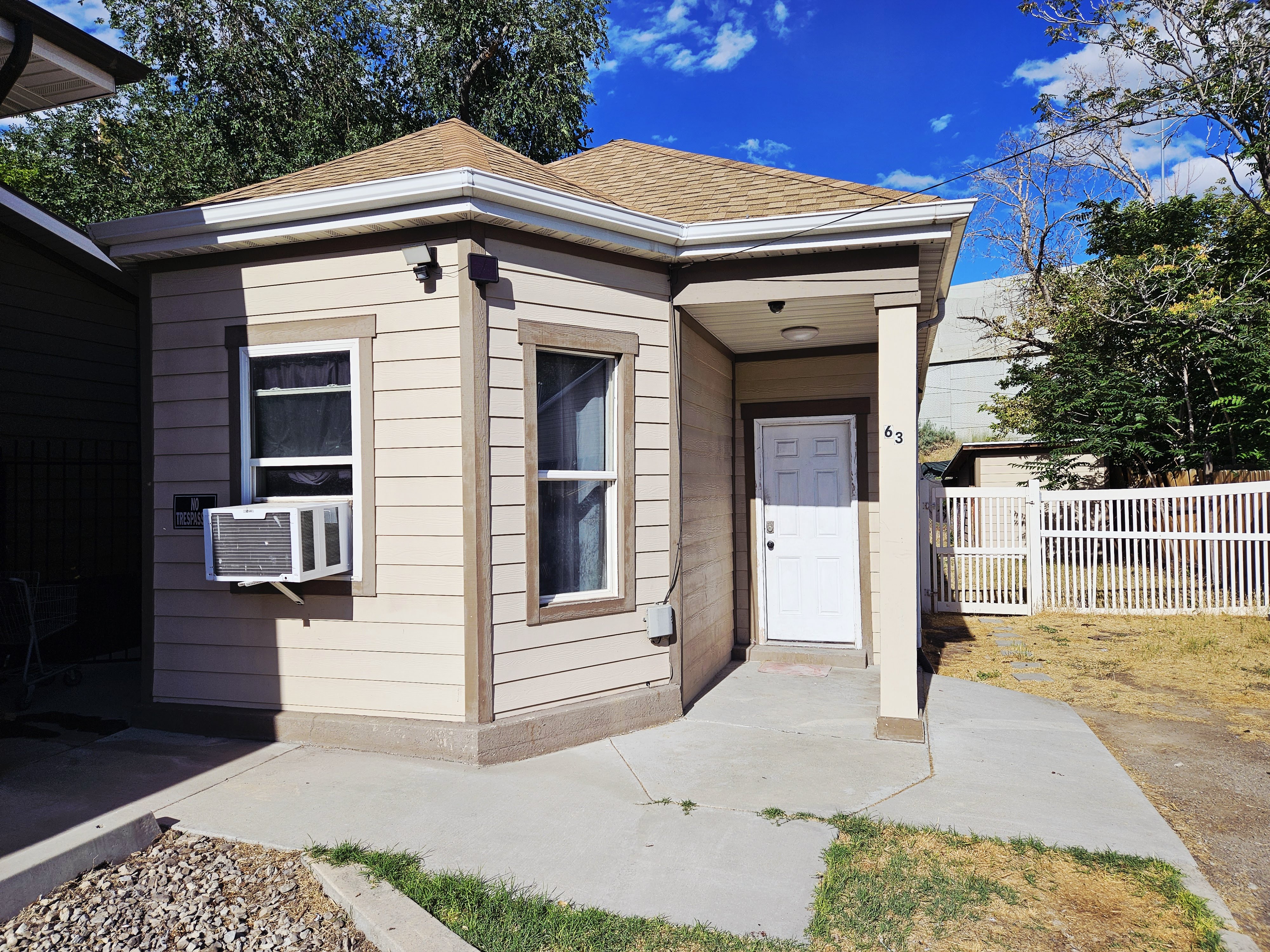 Single-story residence featuring light-colored siding with contrasting trim