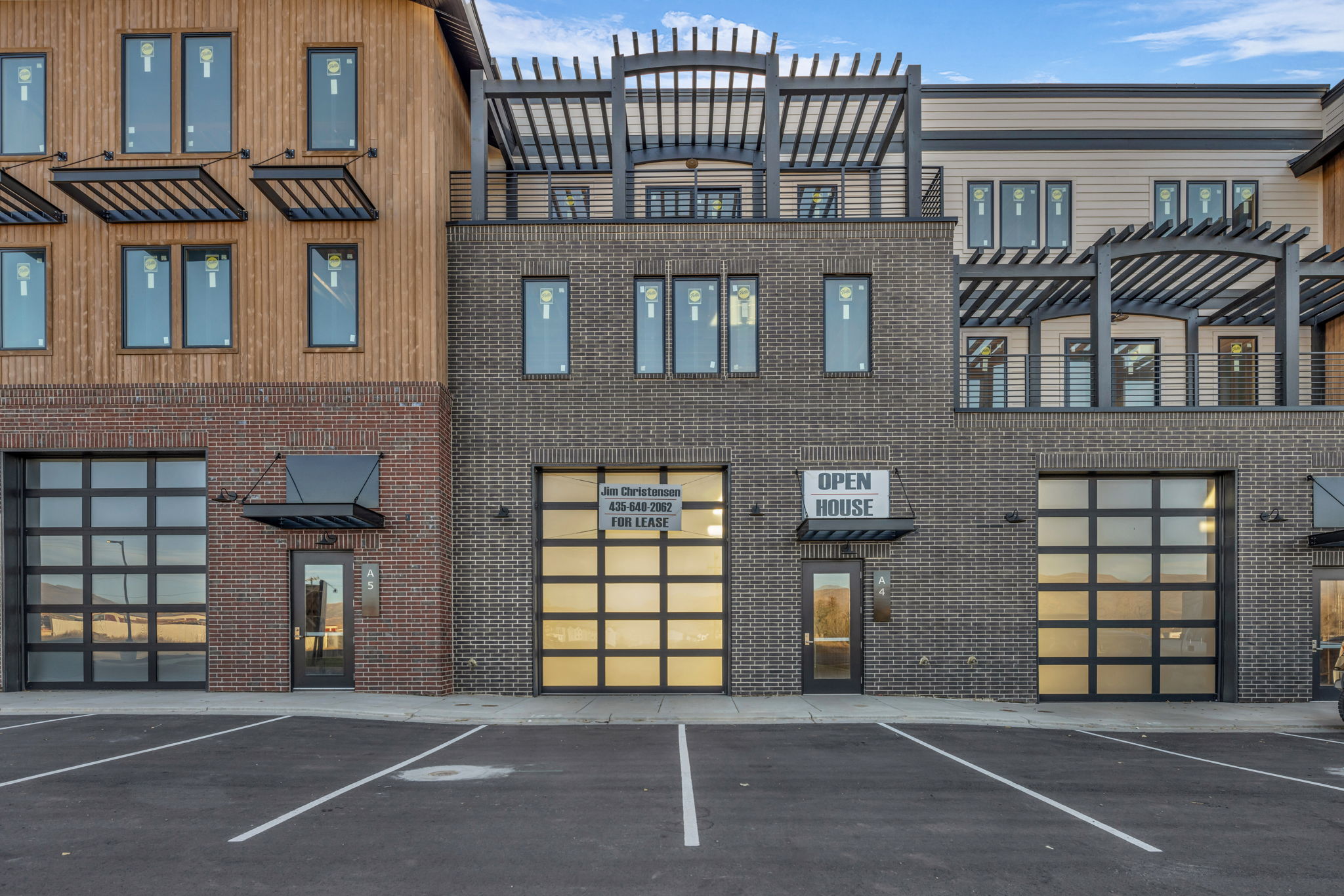 Modern commercial facade featuring dark brick and natural wood-finish siding
