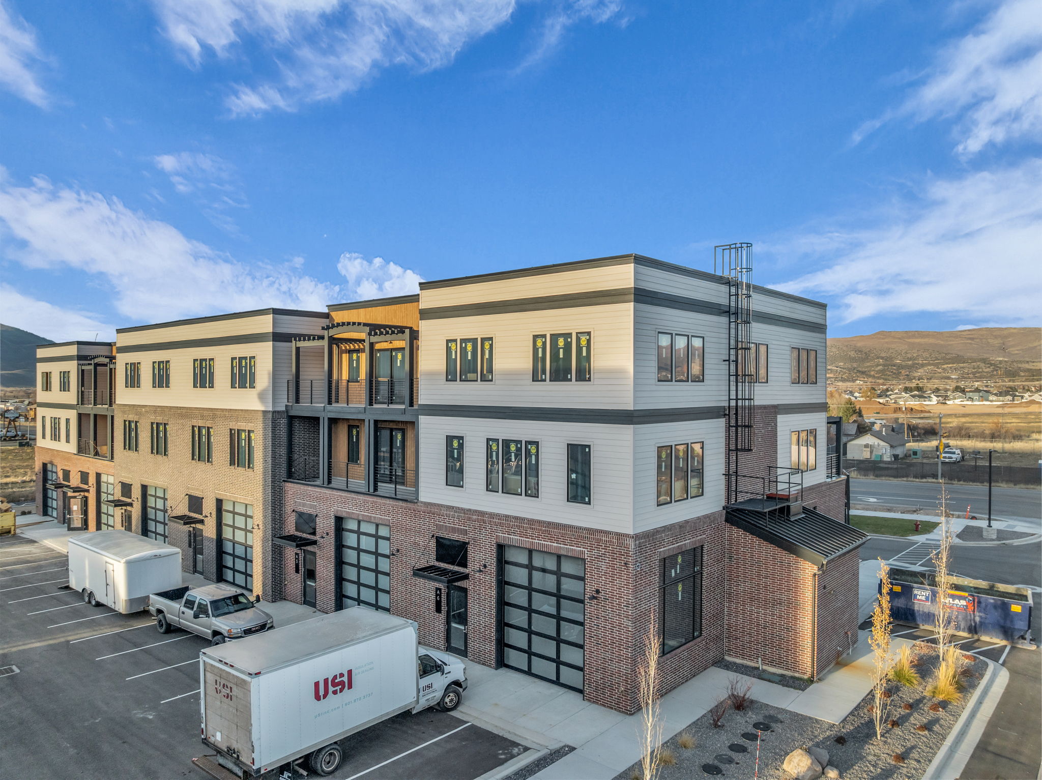Modern multi-story building featuring brick and horizontal siding facades