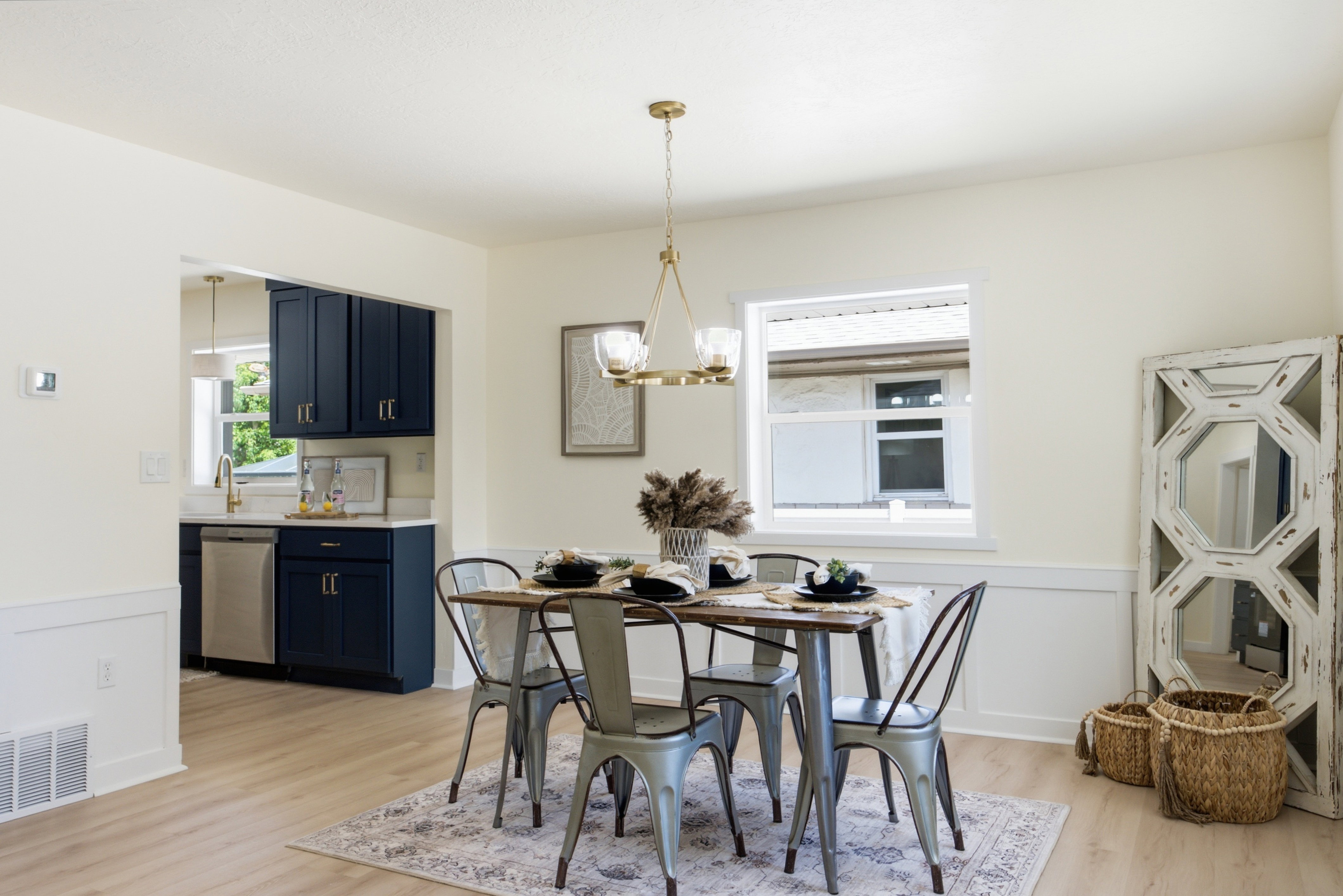 Dining area featuring wood-finish flooring, wainscoting, and an open layout to the kitchen