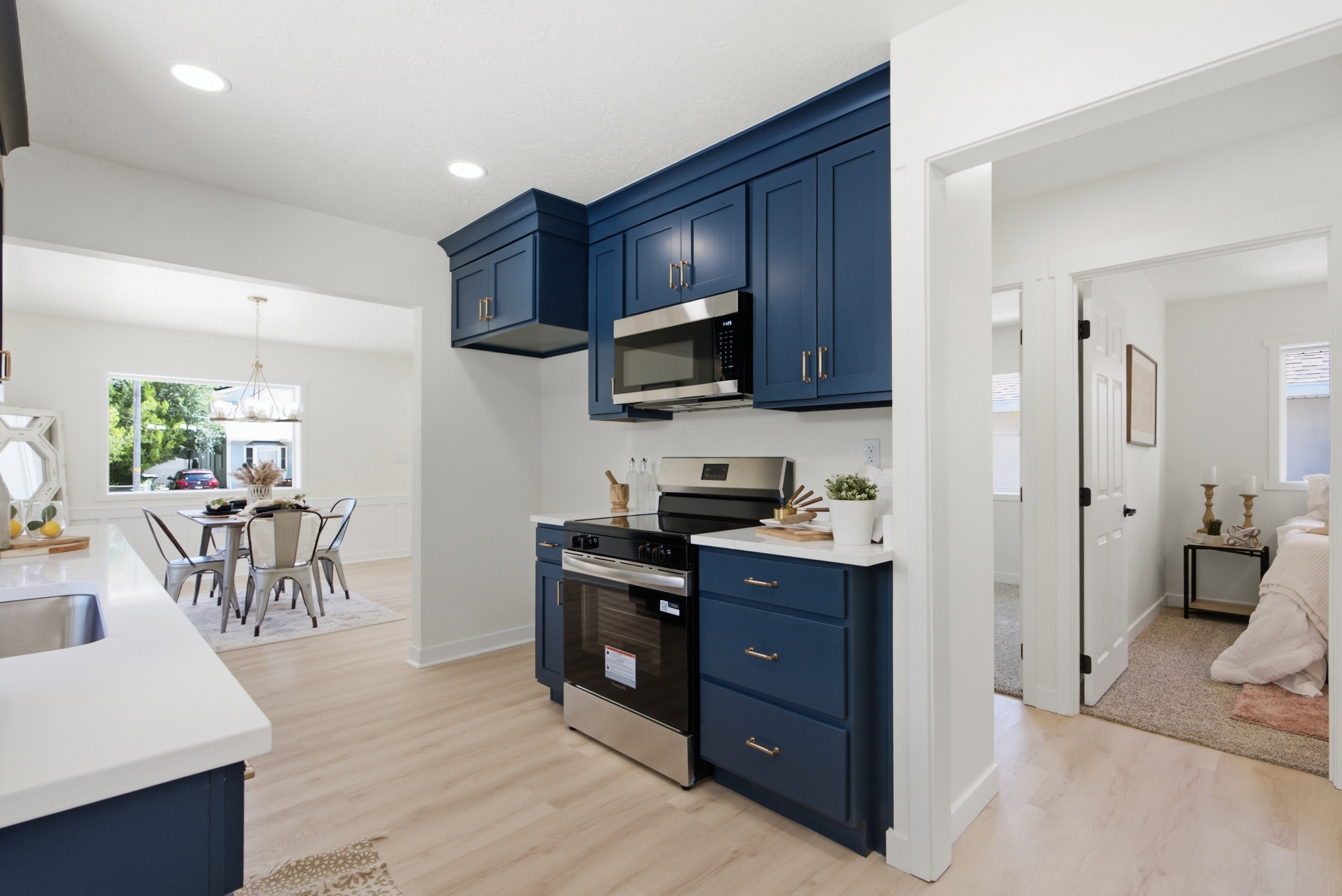 Contemporary kitchen featuring blue shaker-style cabinetry, stainless steel appliances, and white countertops