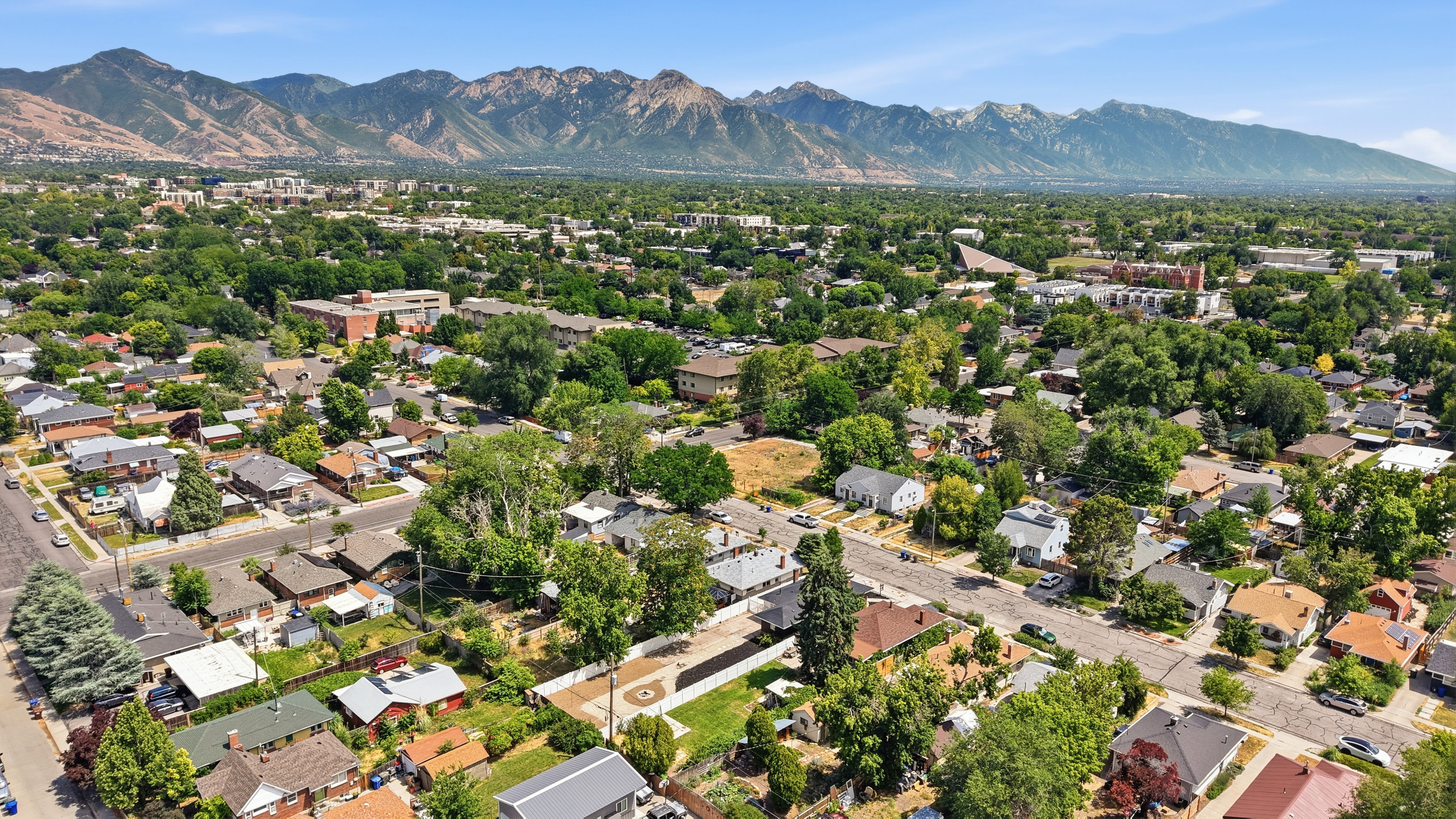 Expansive residential area featuring a variety of homes, mature trees, and mountainous topography