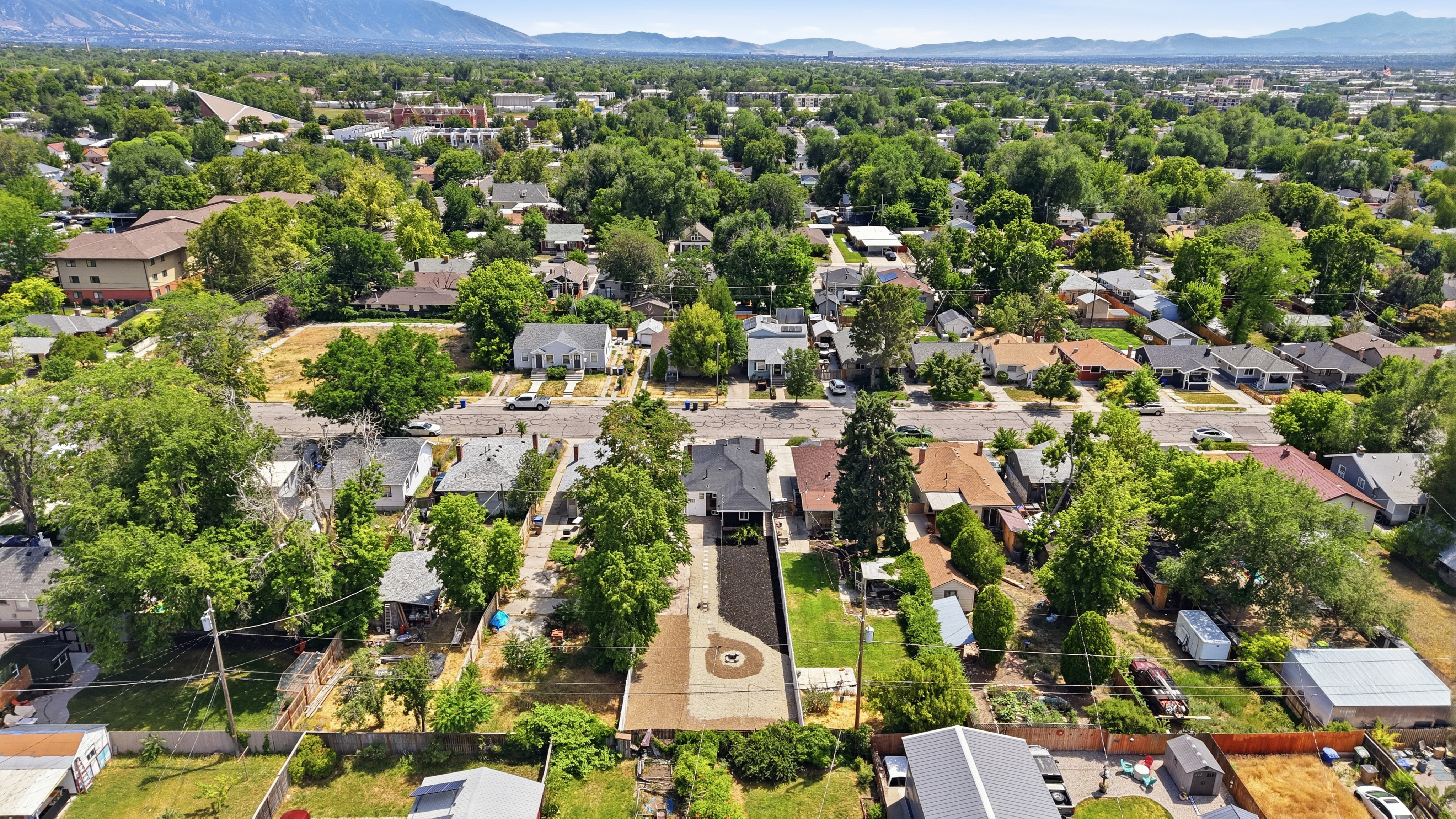 Residential neighborhood with mature trees, established streets, and mountain backdrop