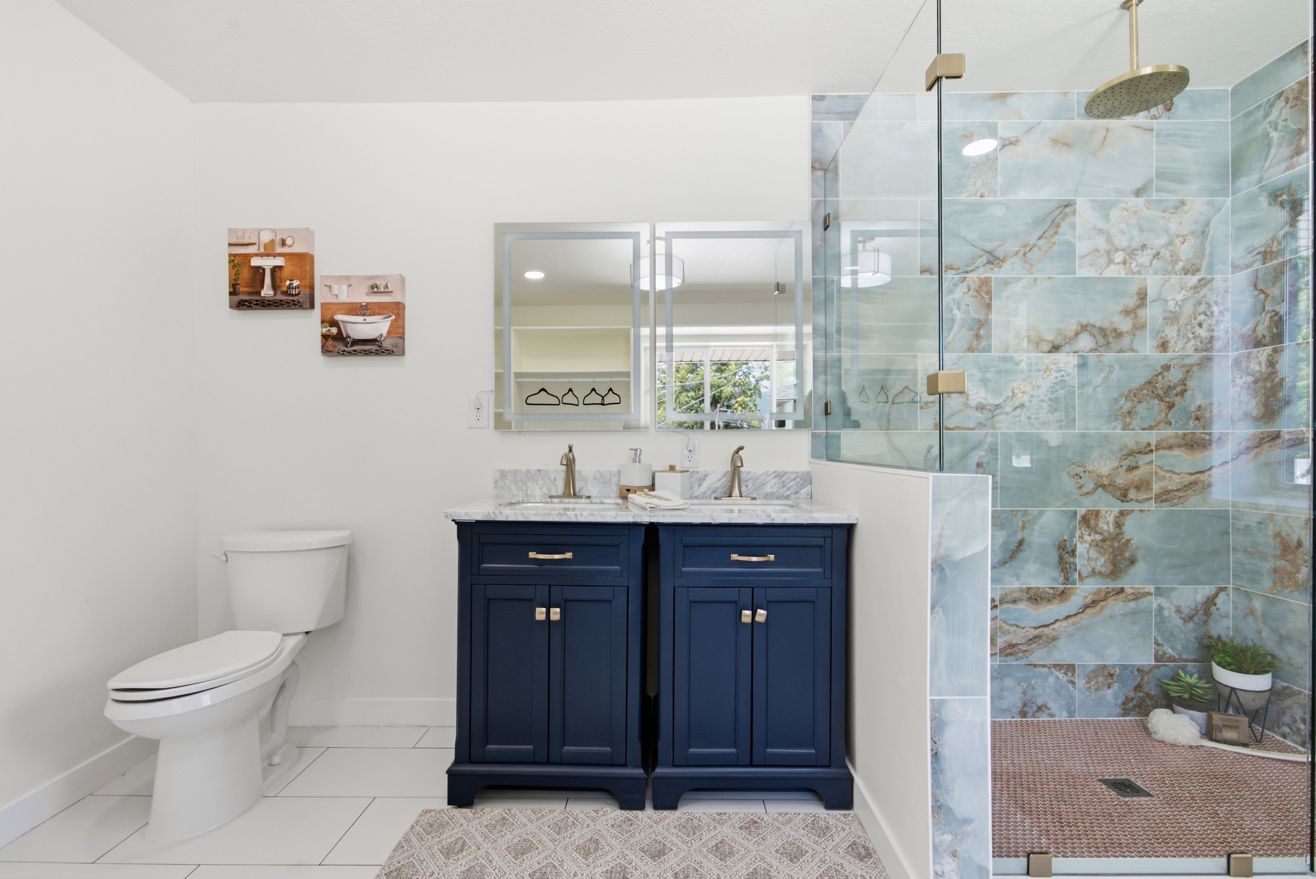 Dual navy vanity with stone countertops and brushed nickel fixtures