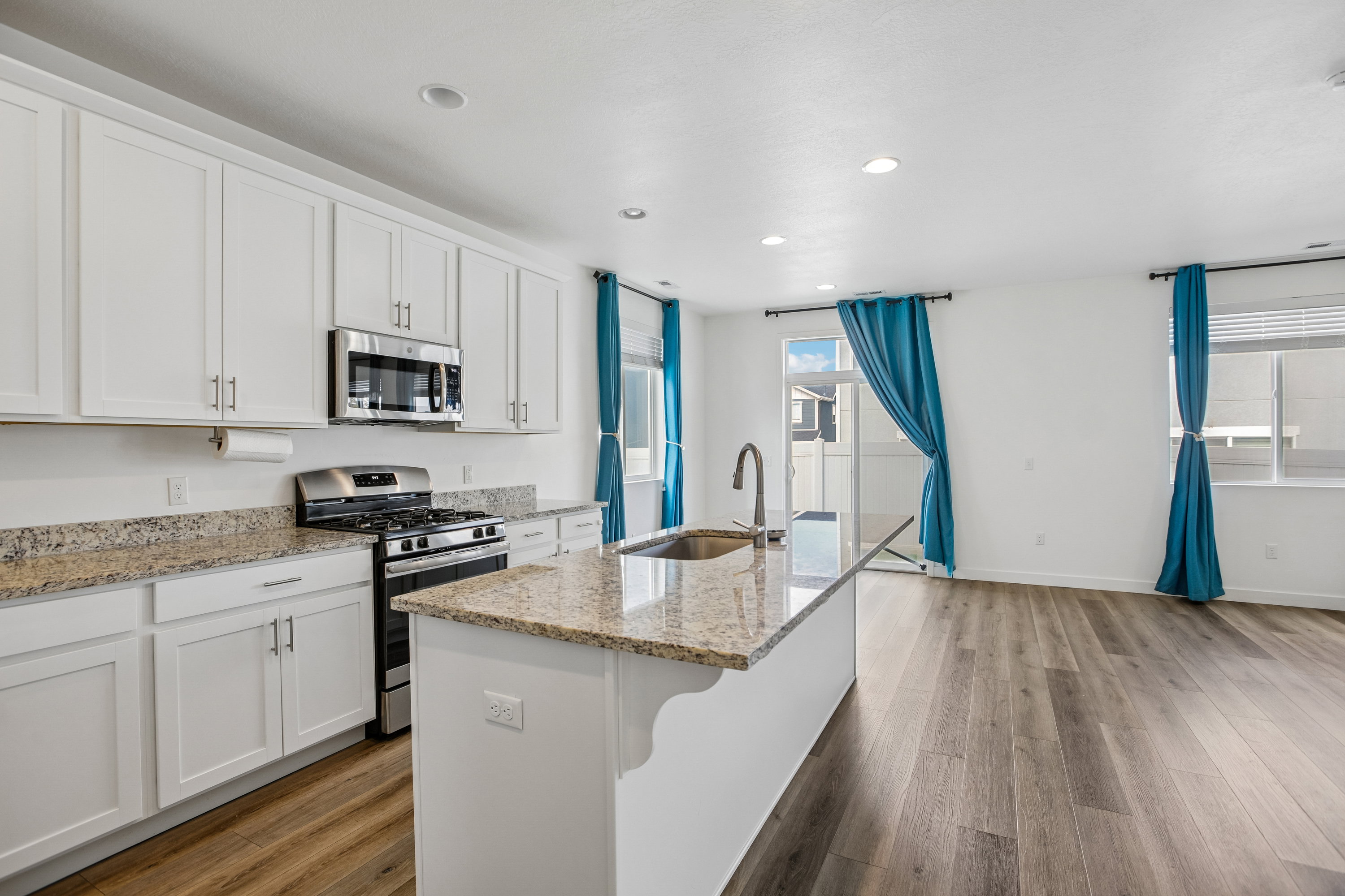 Kitchen featuring white shaker-style cabinetry, stainless steel appliances, and granite countertops