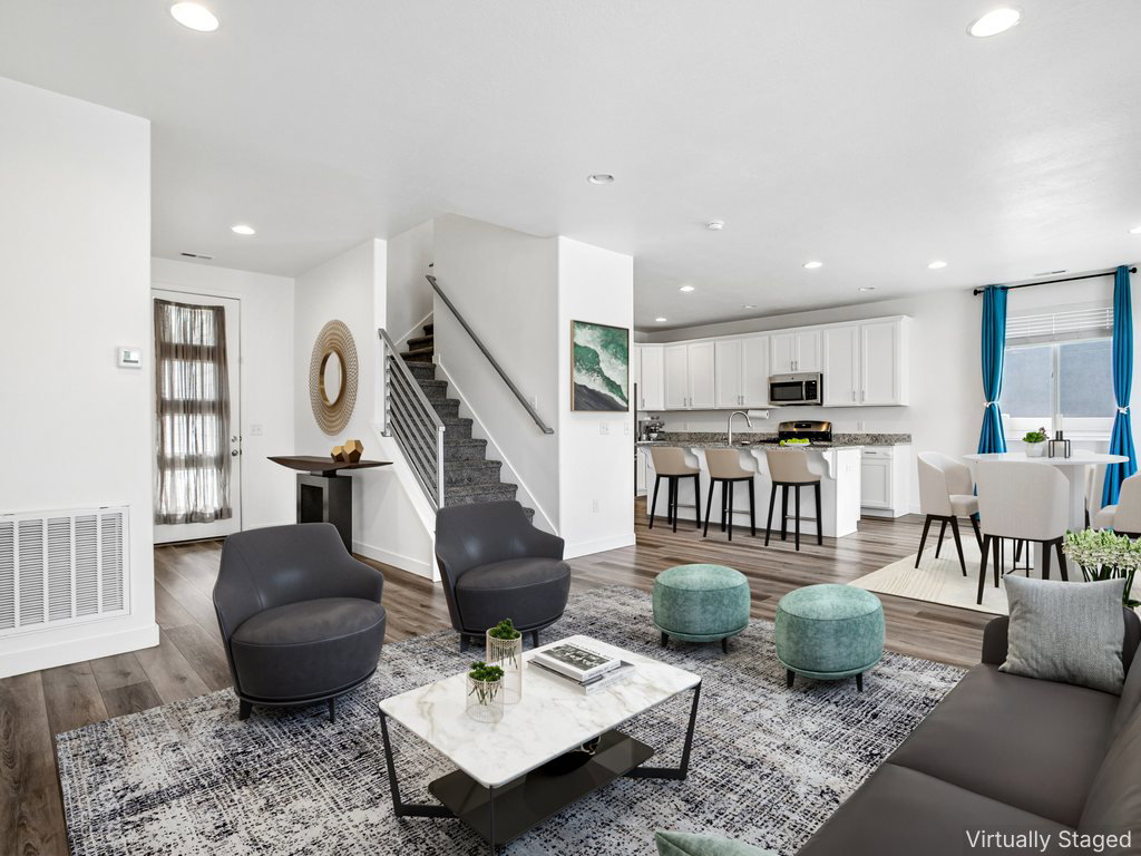 Open-concept living area featuring wood-finish flooring and recessed lighting