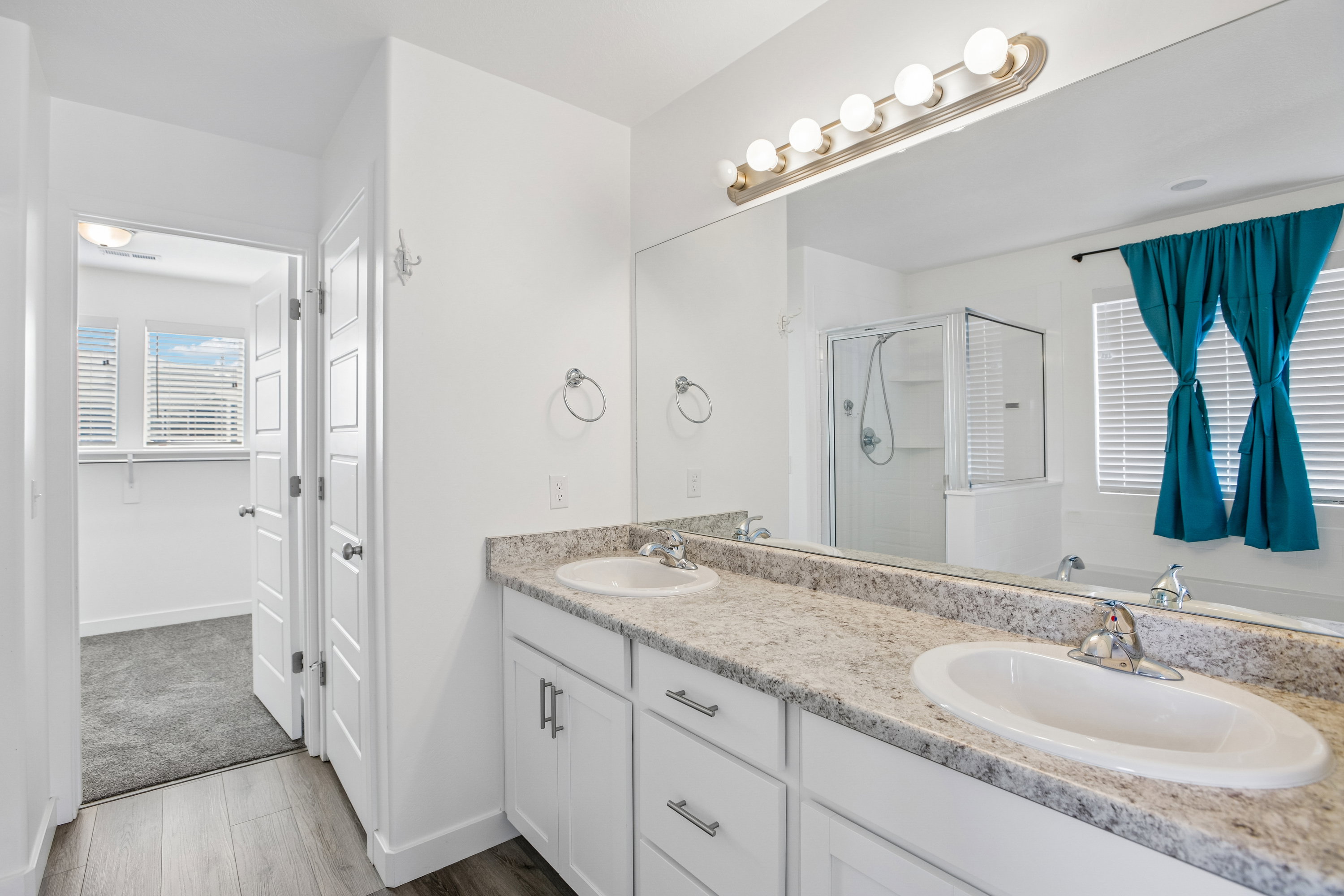 Bathroom featuring a double vanity with light-toned countertops and undermount sinks