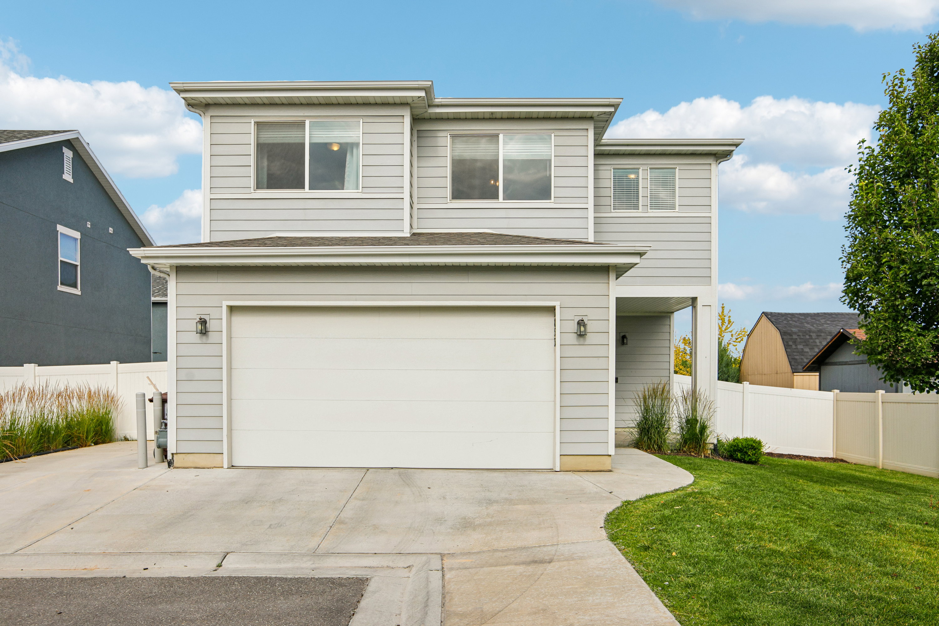 Modern two-story residence featuring light gray siding and white trim