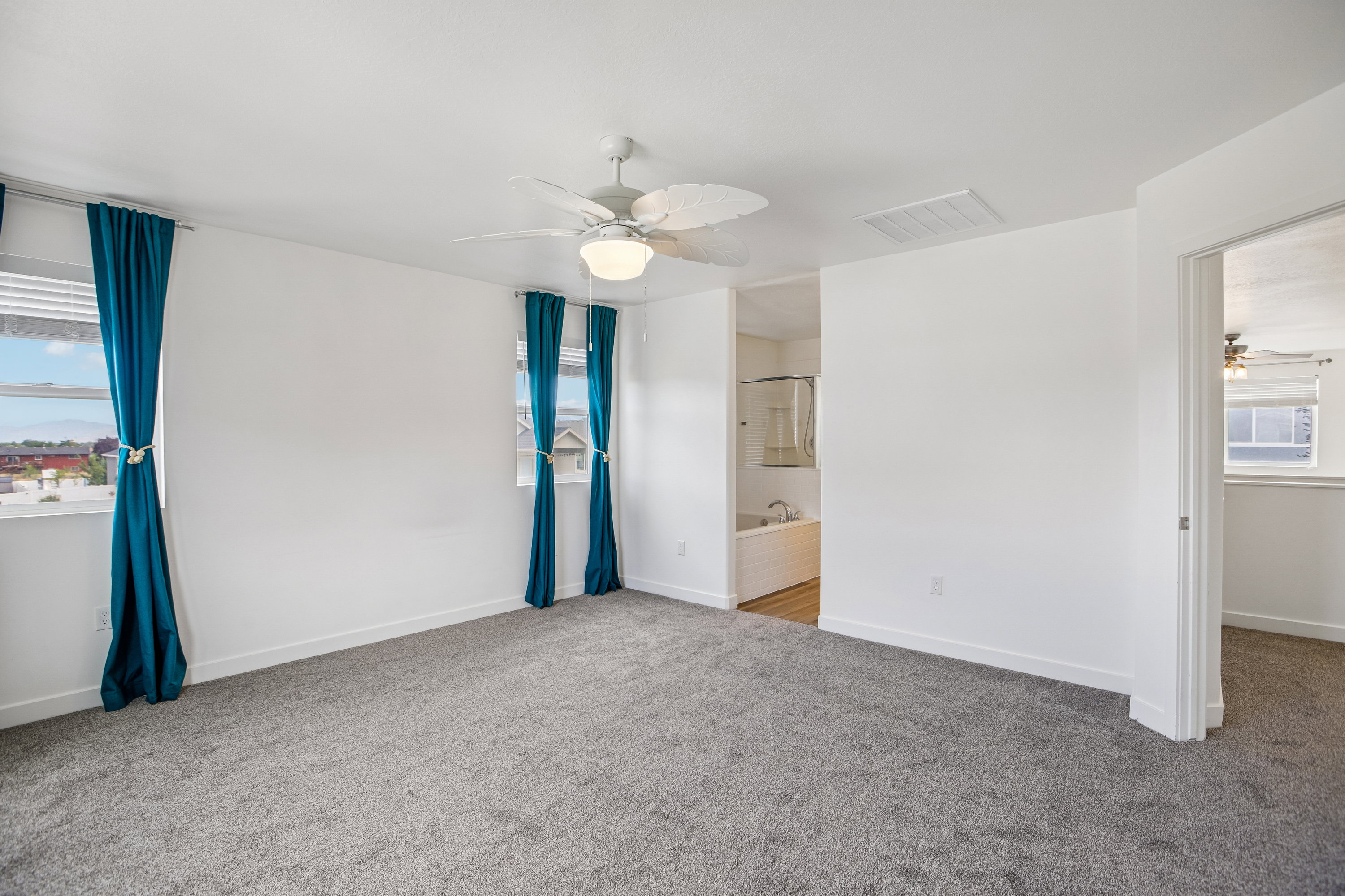 Spacious room featuring neutral carpeting and white walls