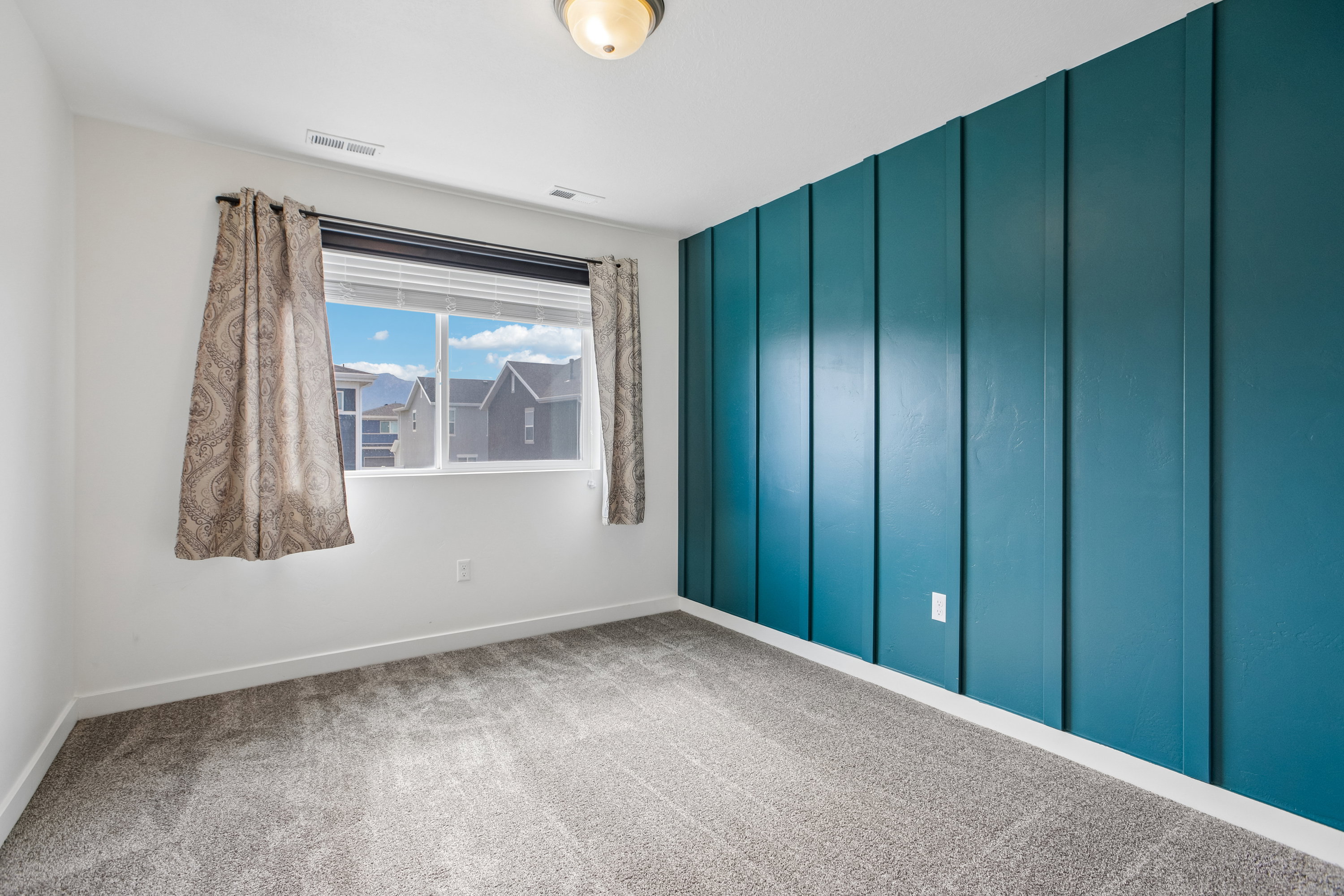 Room featuring a statement wall with teal vertical paneling