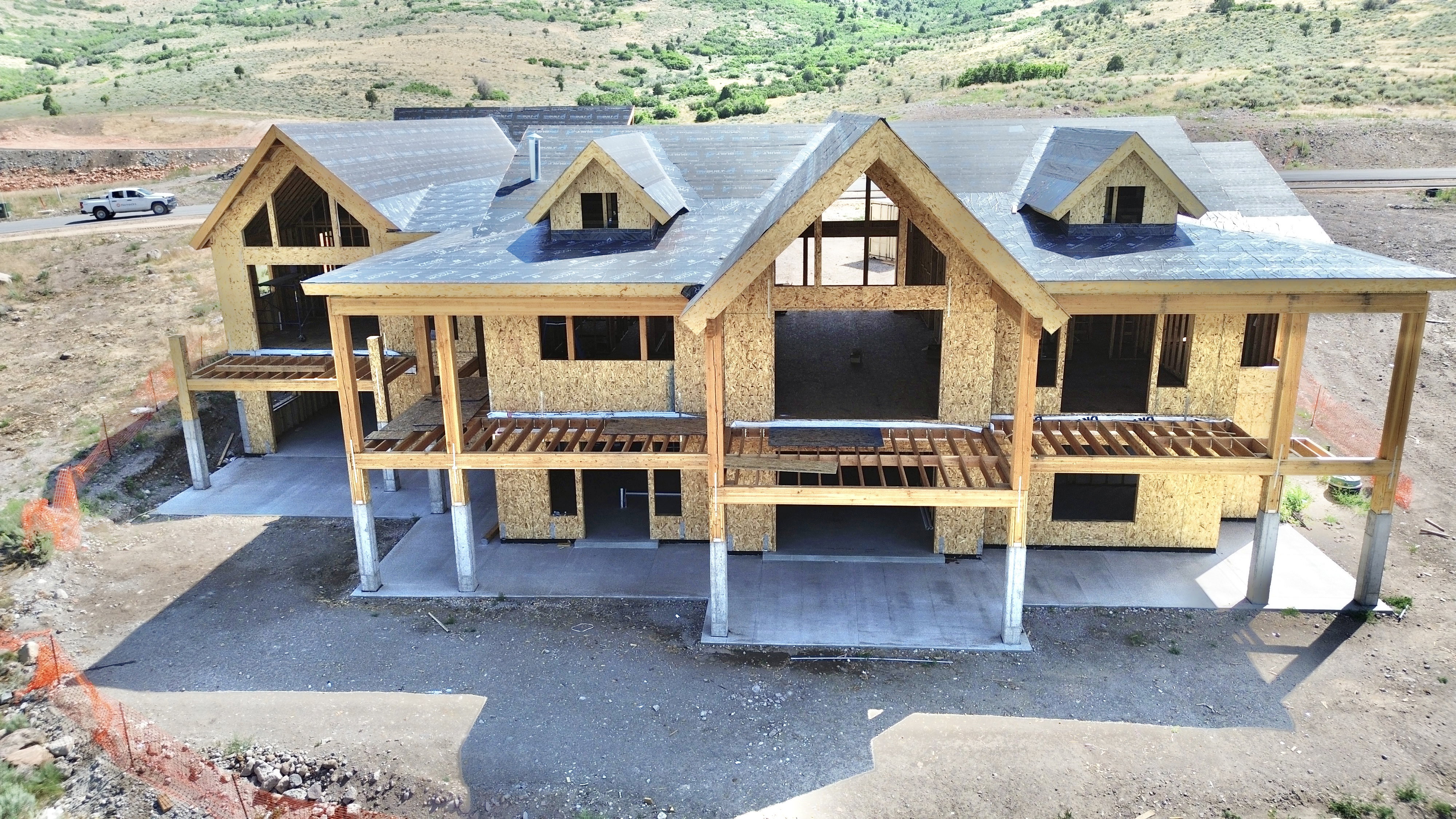 Spacious multi-level property under construction featuring multiple gable rooflines and large window openings