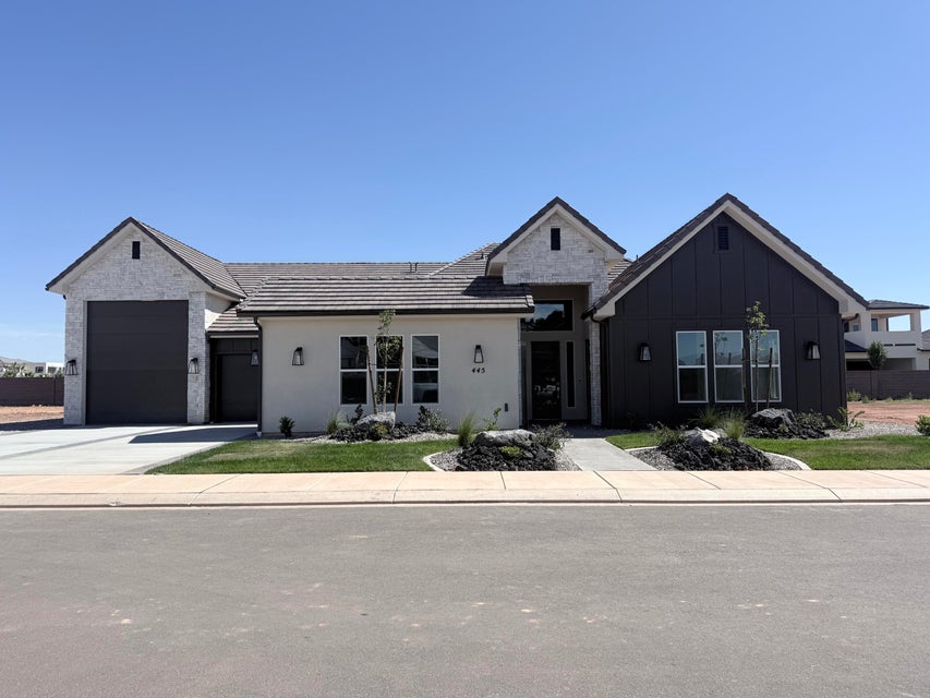 Contemporary facade featuring a white stucco exterior with dark board and batten siding