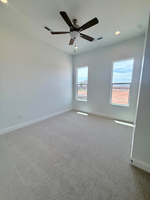 Spacious room featuring light-colored carpeting and white baseboards