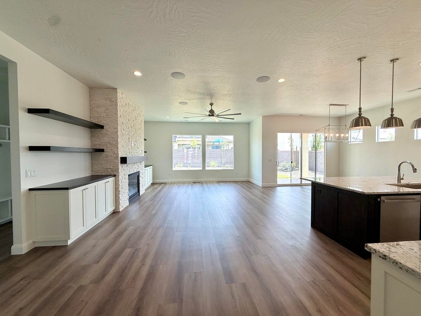 Open-concept living area with wood-finish flooring, recessed lighting, and a ceiling fan