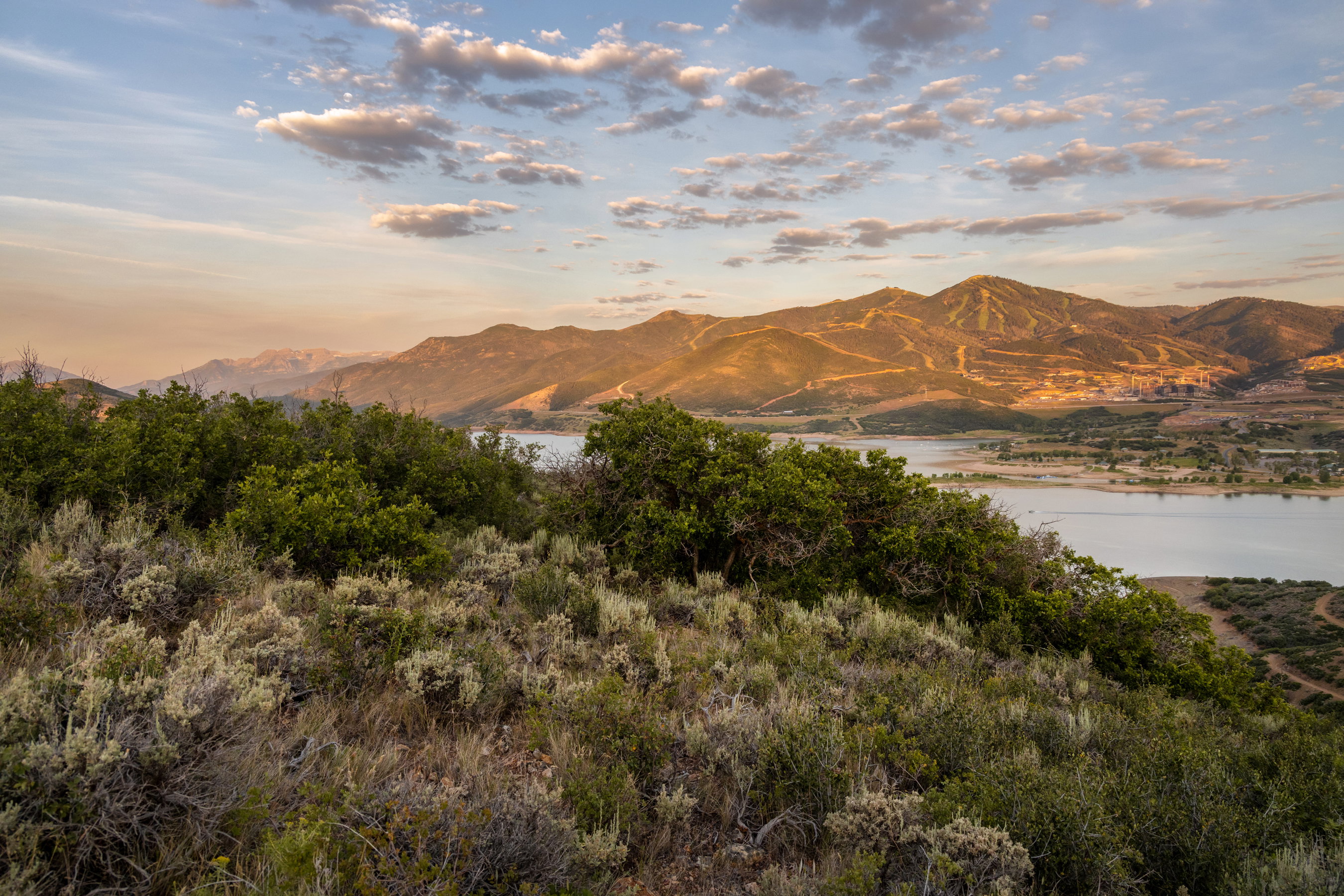 Expansive landscape with a prominent body of water, rolling hills, and distant mountains