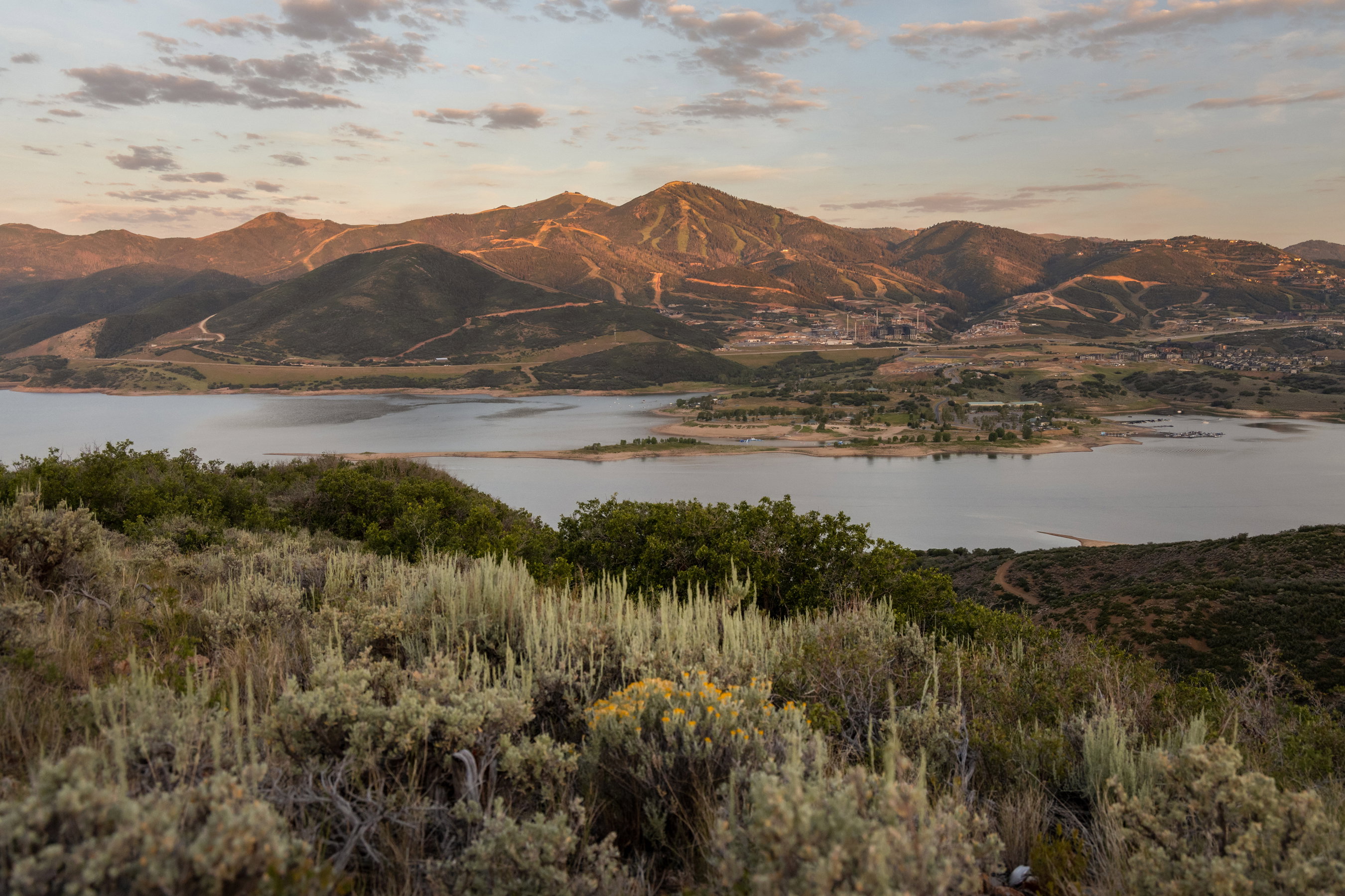 Expansive mountain and lake scenery featuring a distant marina and varied terrain