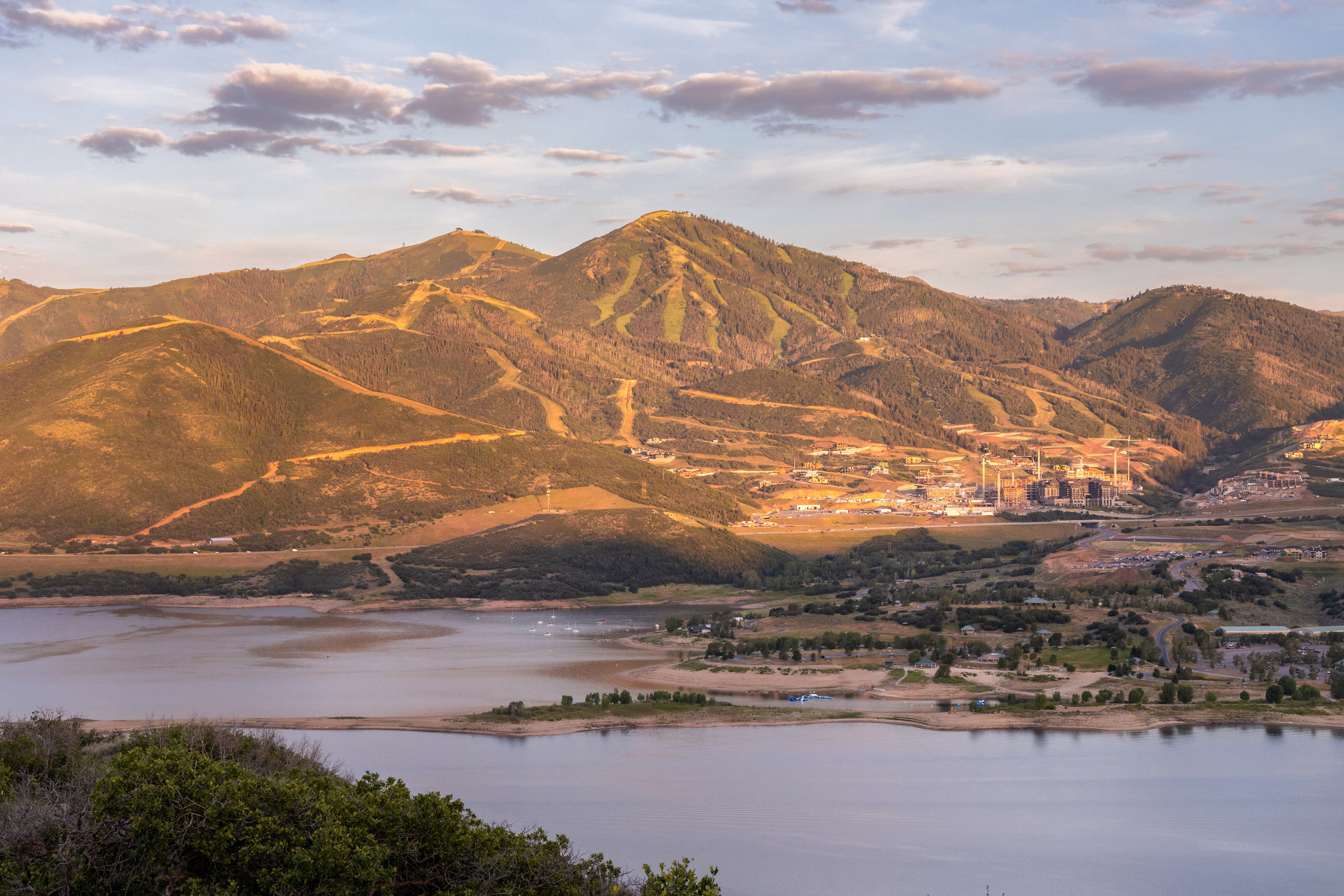 Expansive mountain and lake scenery featuring distant ski slopes, a large body of water, and surrounding terrain