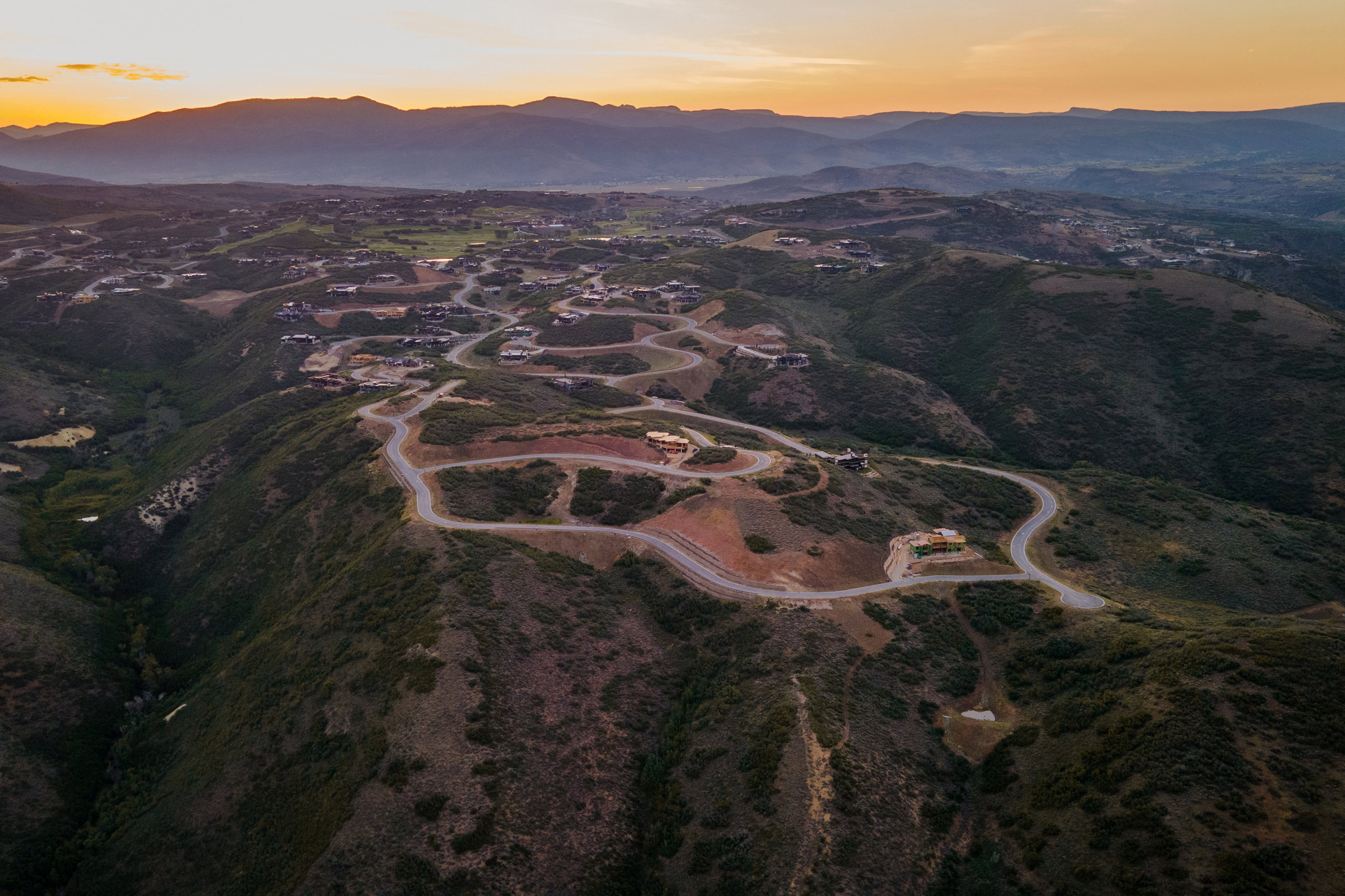 Expansive hillside development featuring winding roads and mountain scenery