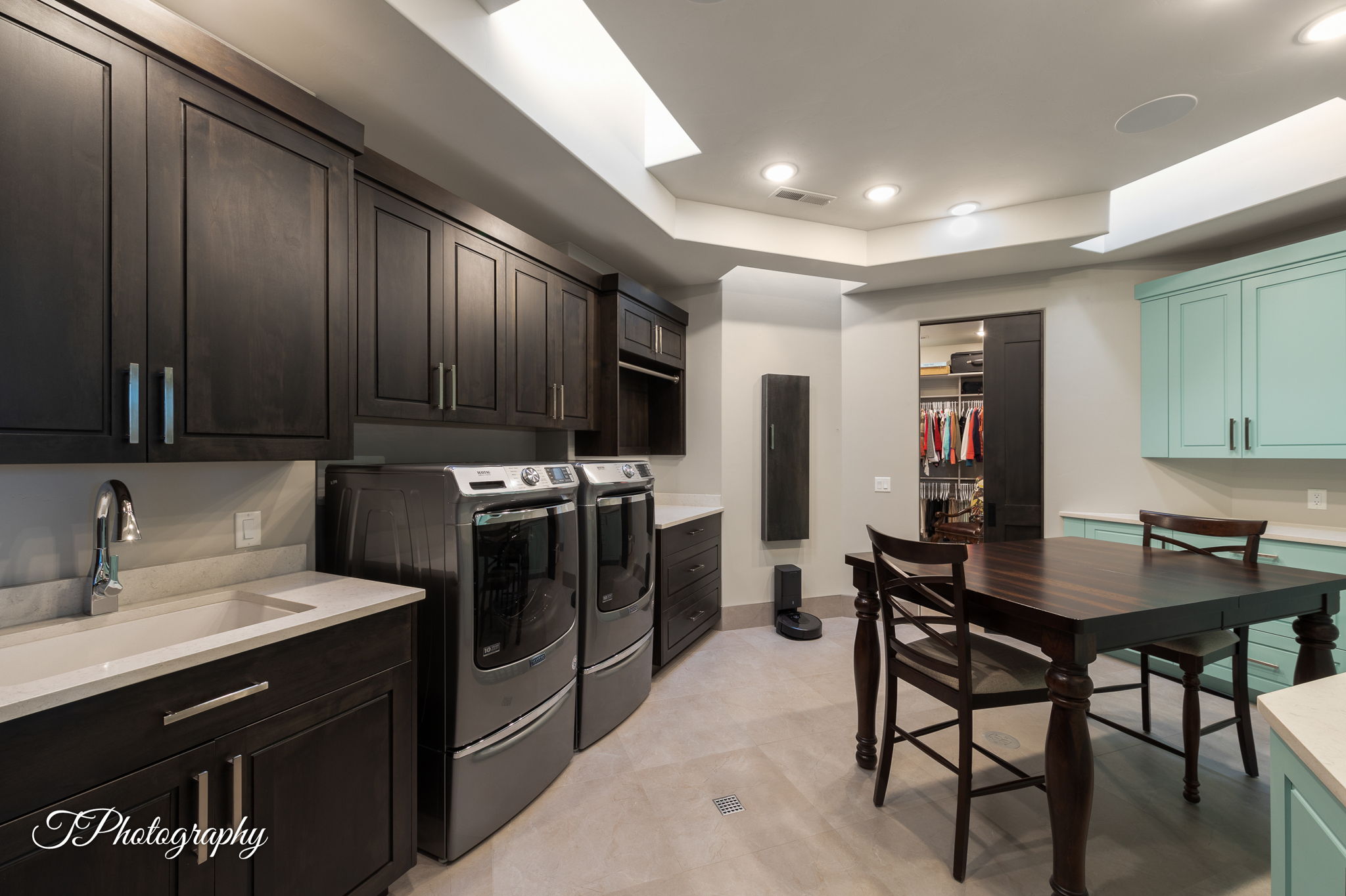 Integrated laundry area featuring dark wood-finish cabinetry, a single basin sink with a chrome faucet, and light countertops