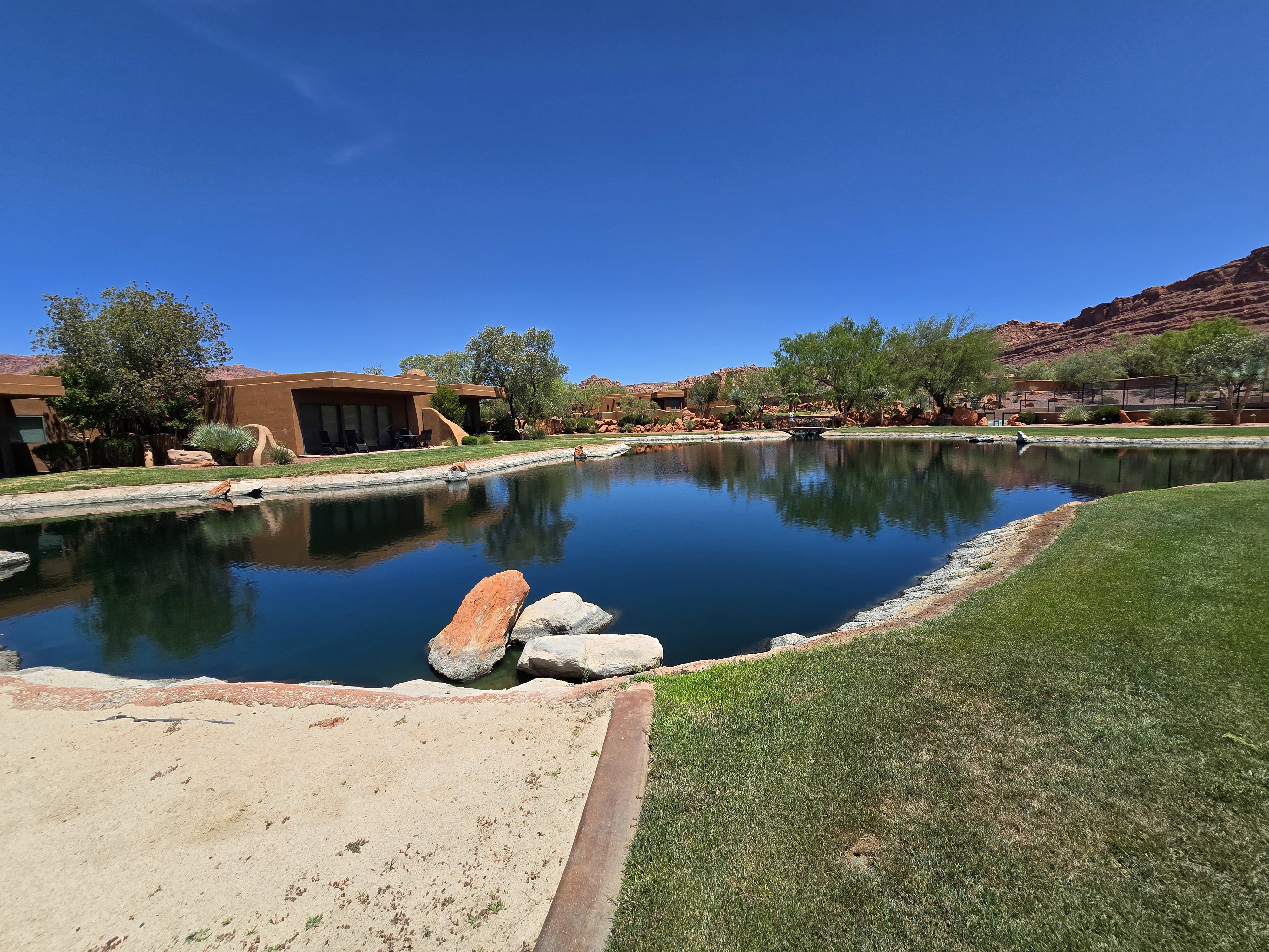 Expansive water feature bordered by manicured lawns and desert landscaping