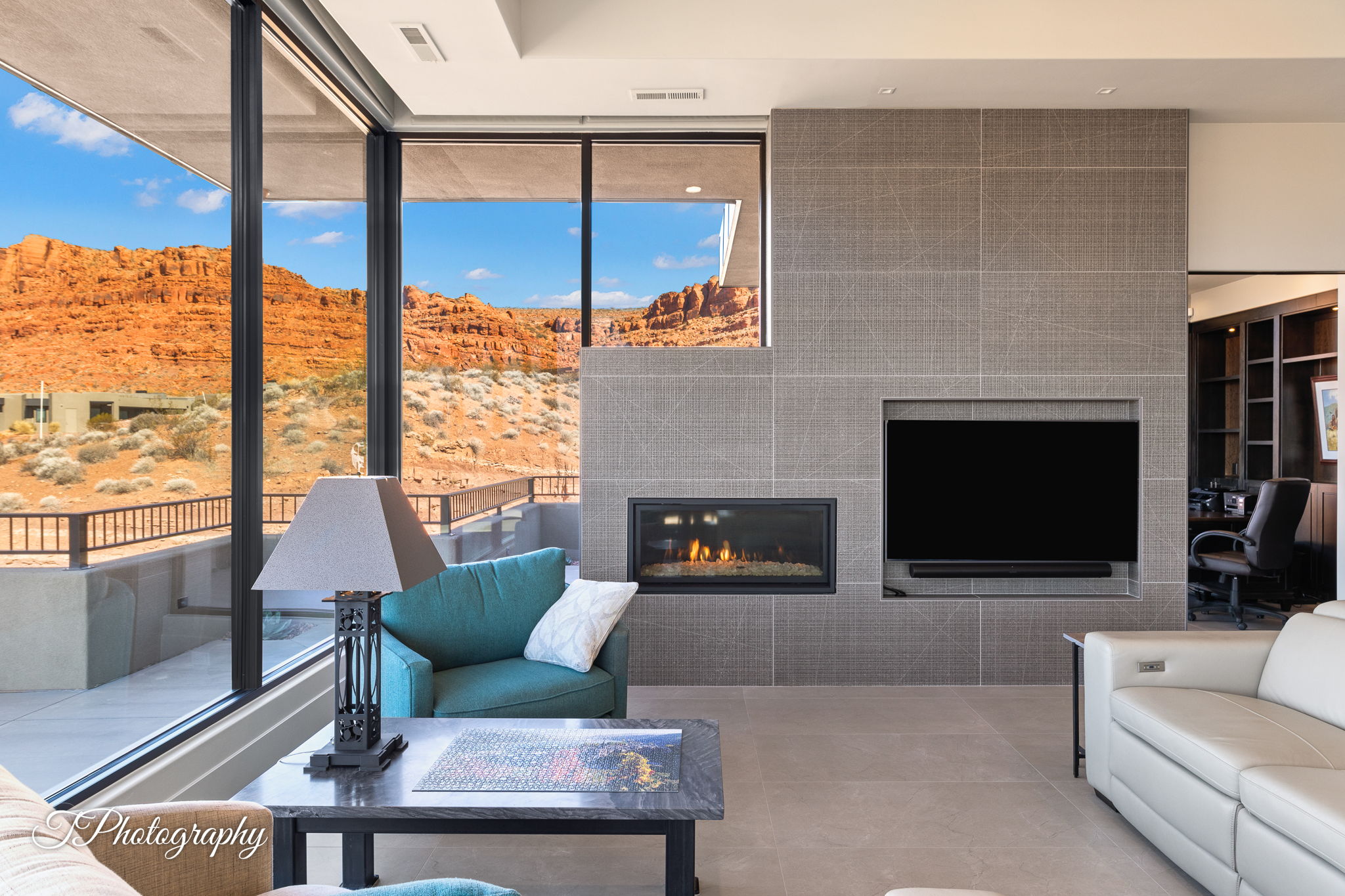 Living area featuring a floor-to-ceiling tiled fireplace surround with an inset flat-screen television and a built-in linear fireplace