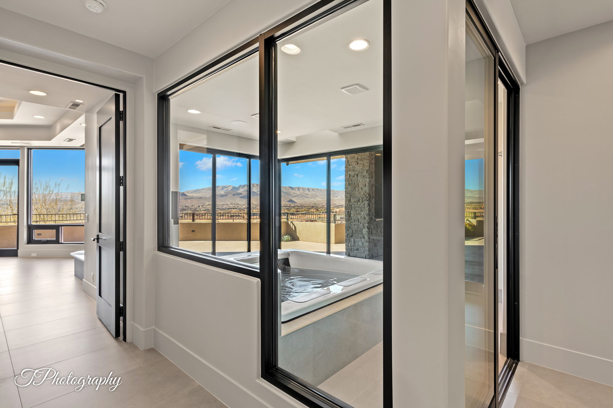 Built-in spa tub surrounded by large format windows, offering direct exposure to the mountain backdrop