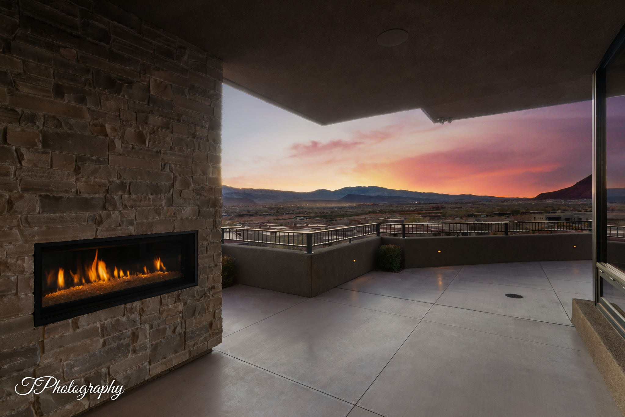 Outdoor patio featuring a linear fireplace within a stacked stone wall