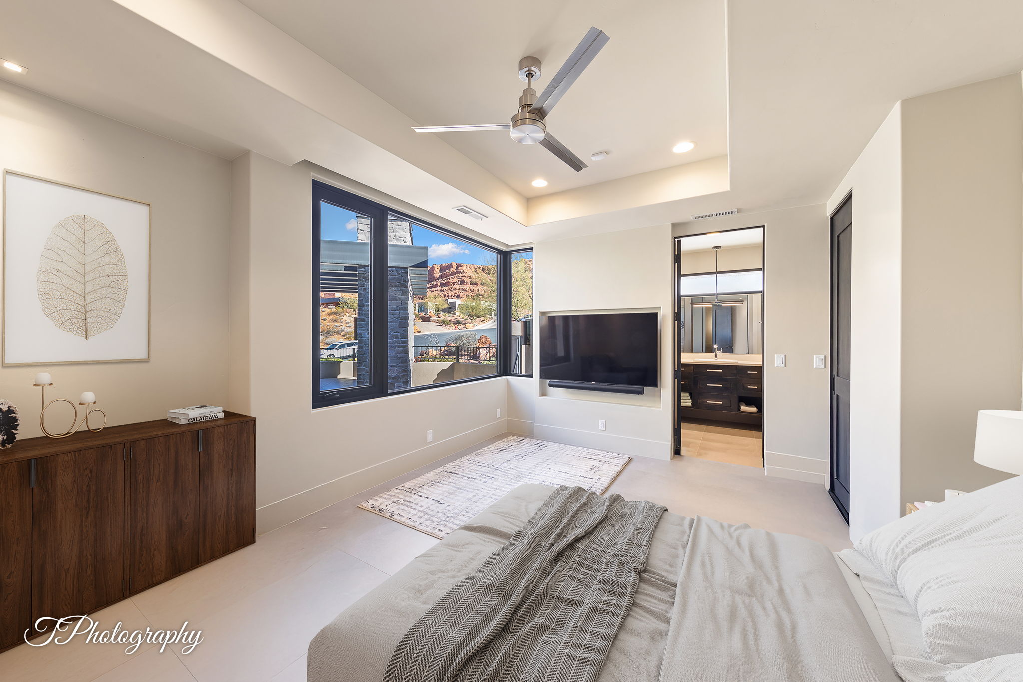 Recessed lighting and ceiling fan overhead, with a wide horizontal window offering exterior views