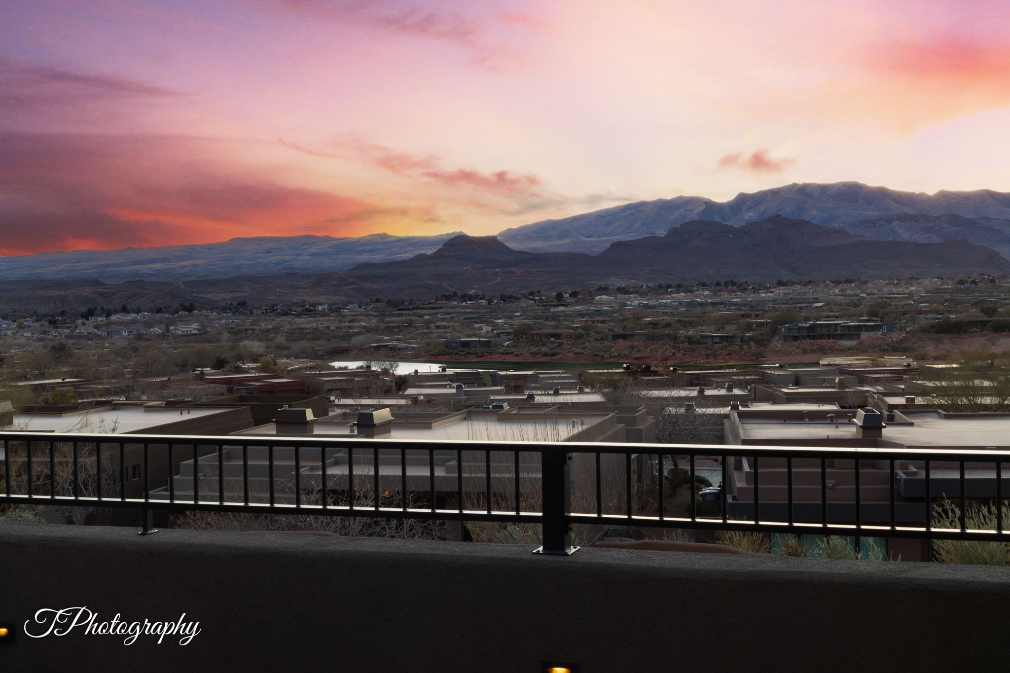 Expansive mountain scenery with a vibrant sunset backdrop from a private balcony featuring a black metal railing