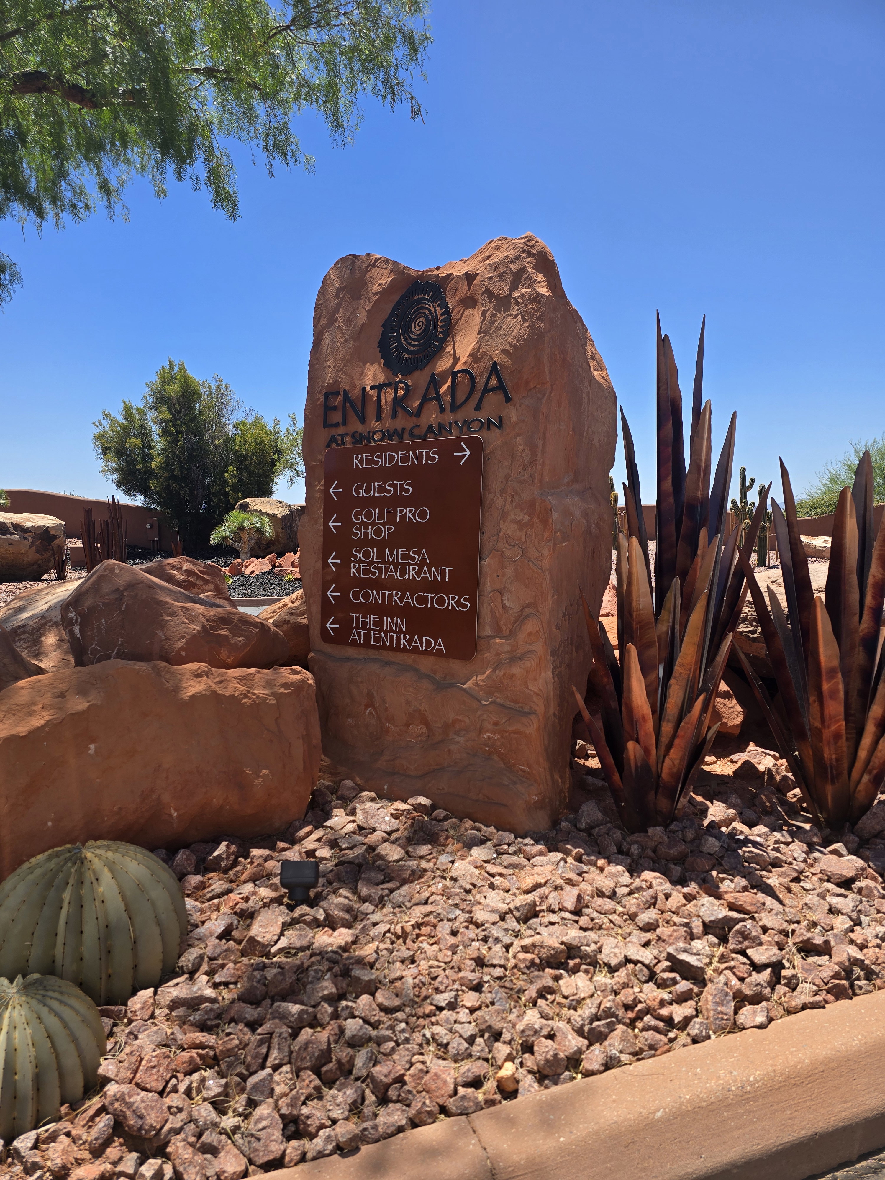Entrada at Snow Canyon signage features a large natural stone monument with carved lettering