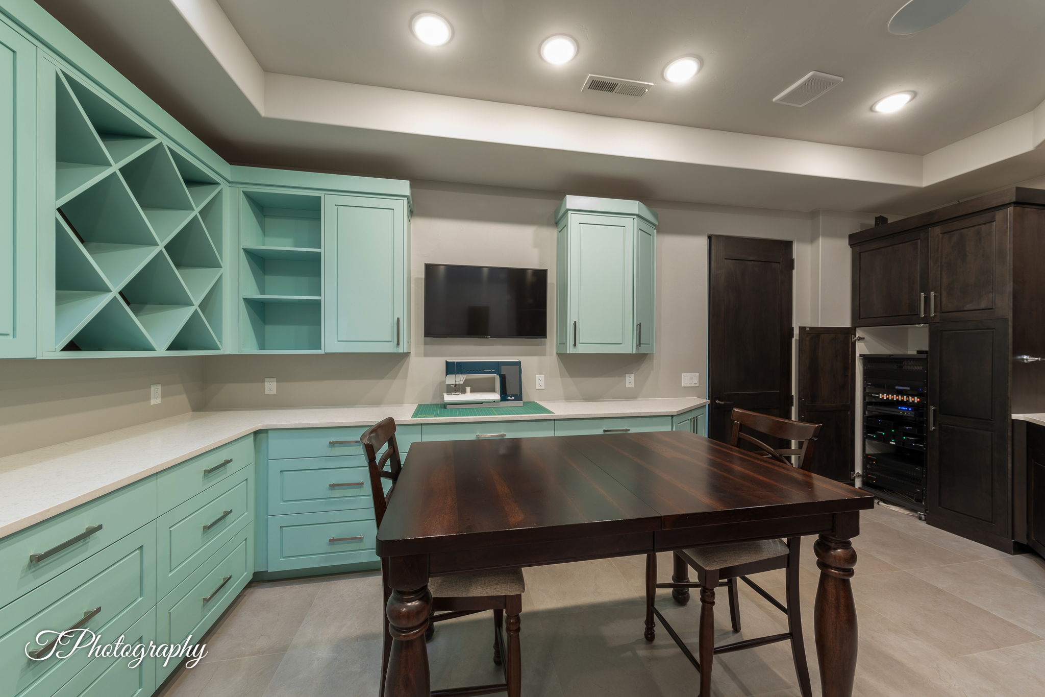Spacious room featuring light blue cabinetry with wine storage, light countertops, and wood-finish flooring