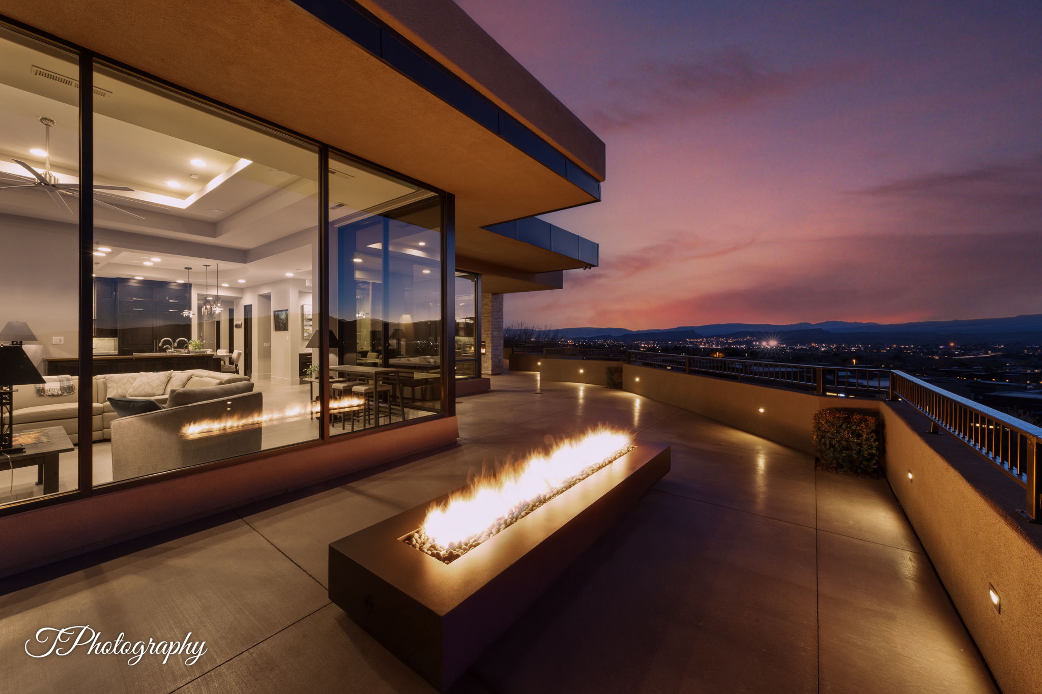 Expansive outdoor patio with a linear fire feature and integrated wall lighting