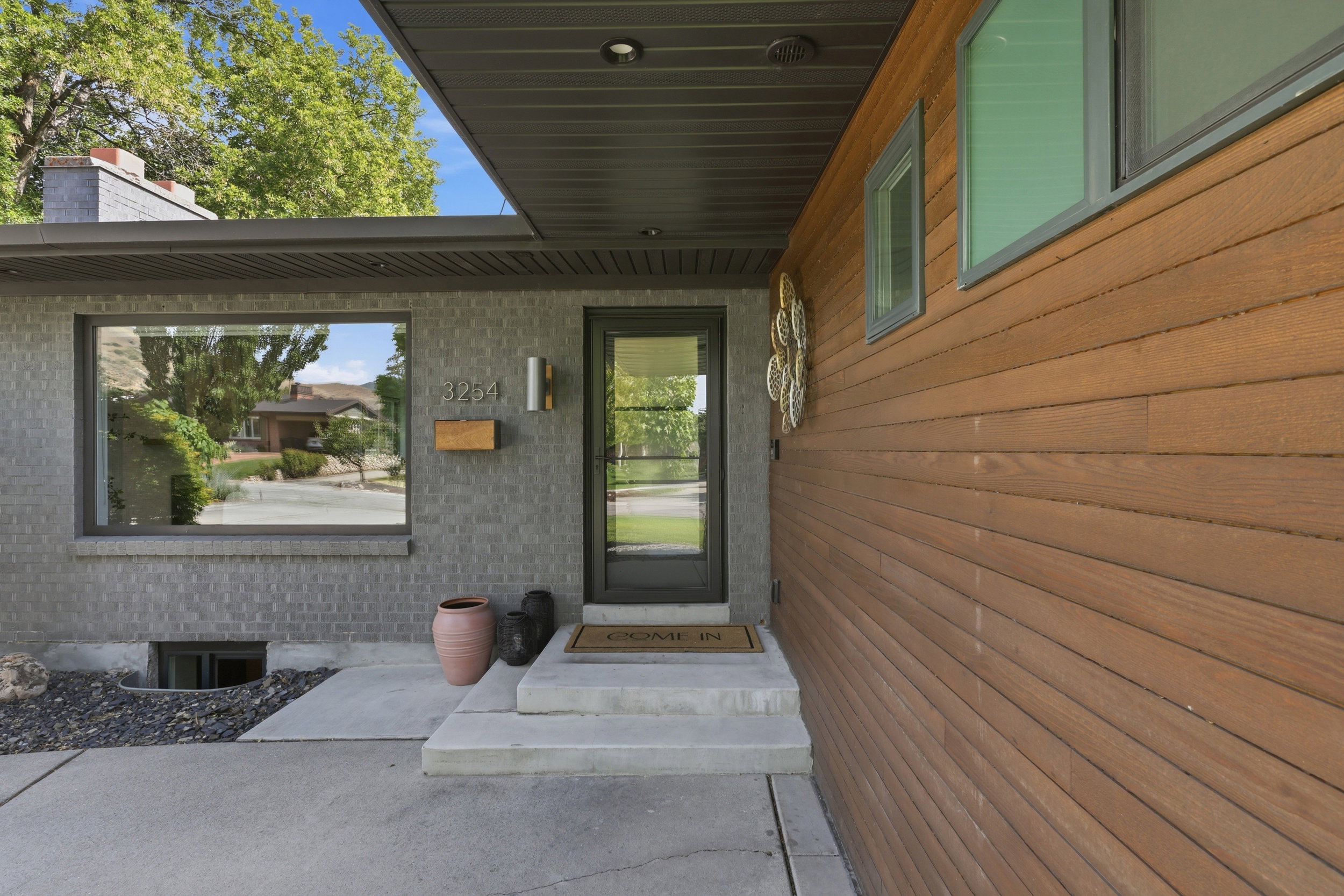Contemporary exterior featuring wood-finish siding and gray brickwork