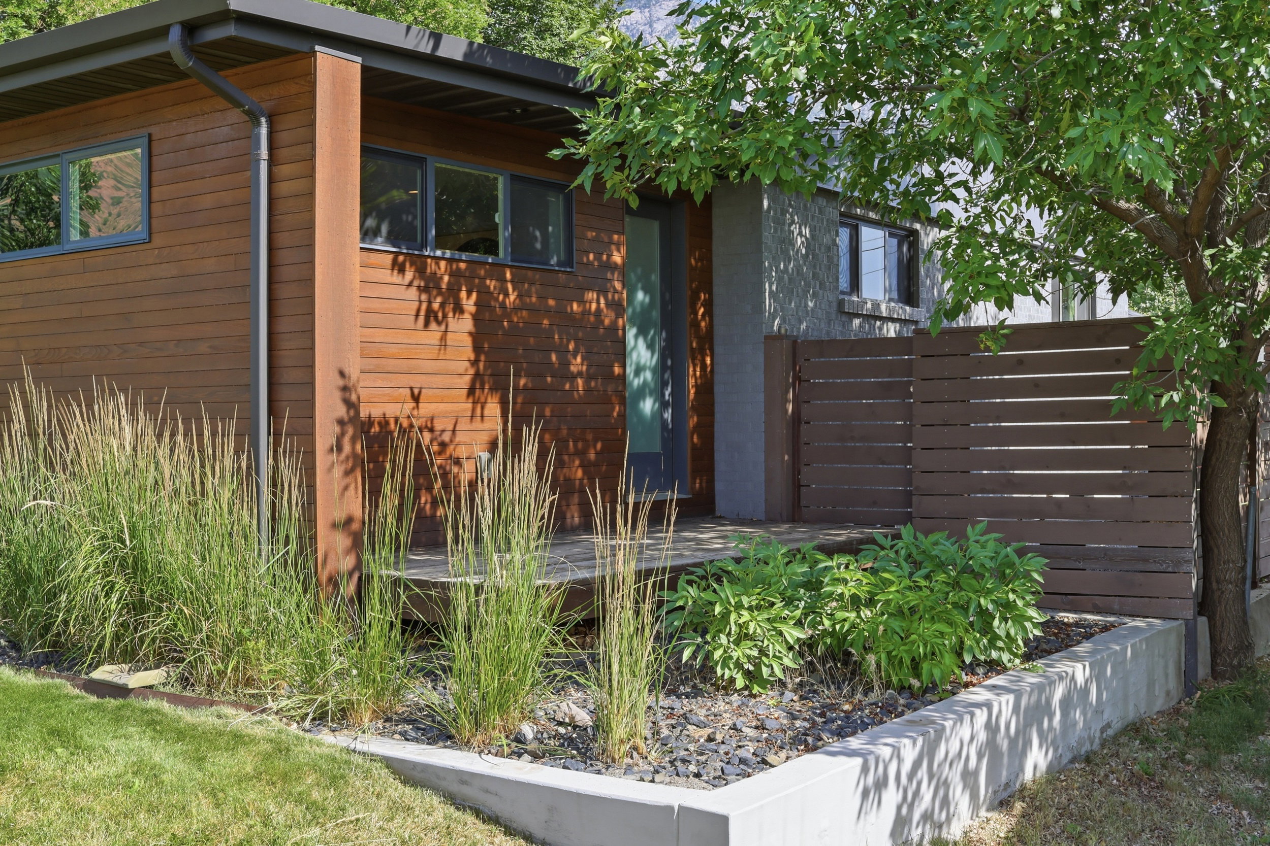 Modern exterior featuring horizontal wood siding, a flat roofline, and a concrete planter box