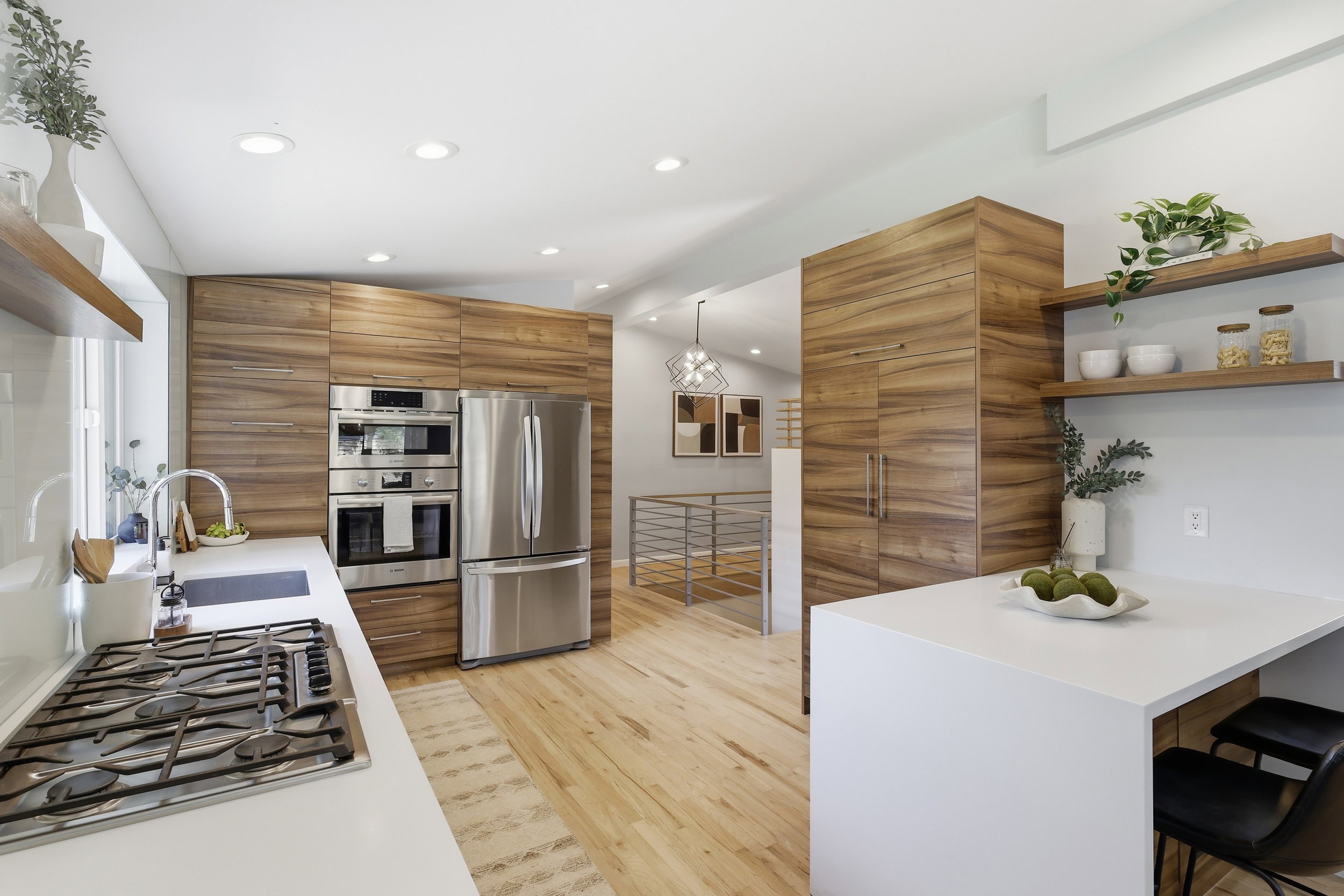 Modern kitchen featuring wood-finish cabinetry, stainless steel appliances, and light wood-finish flooring